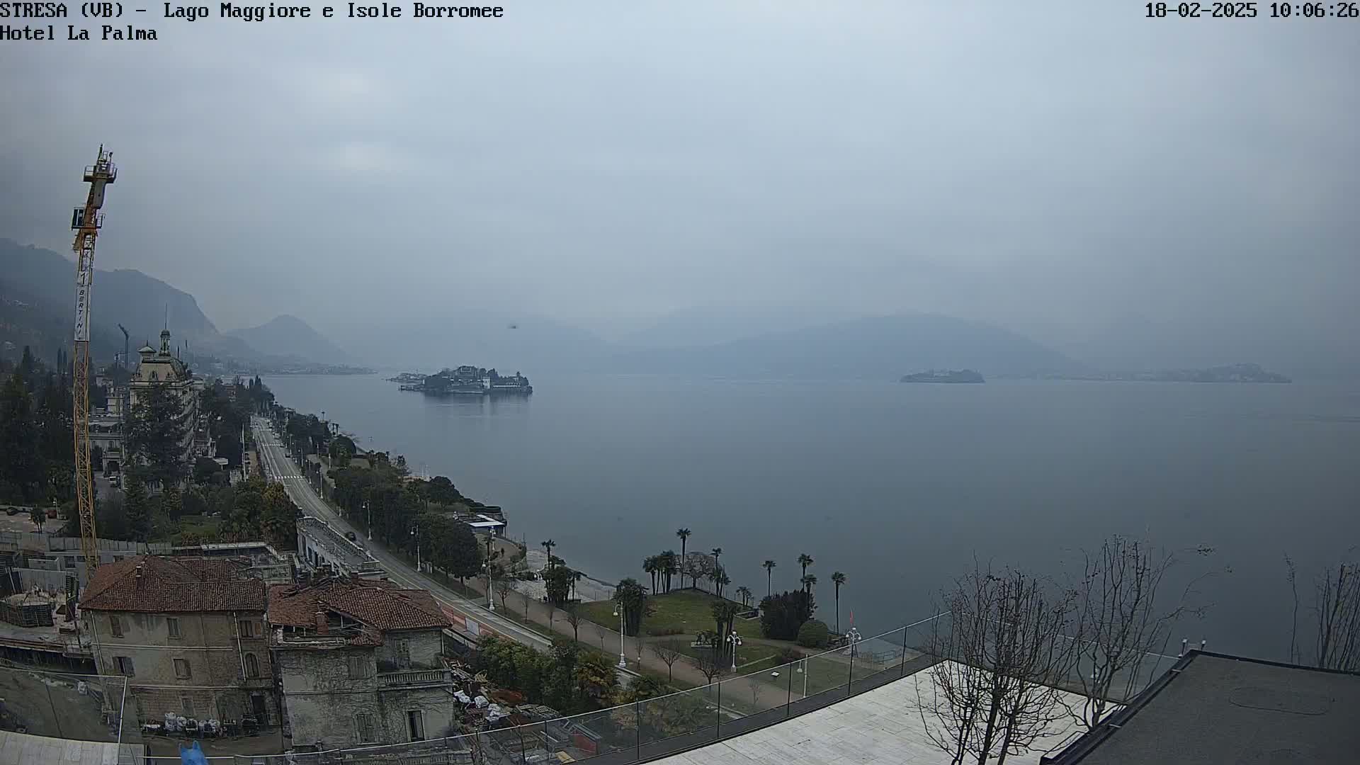 A hazy view of a lake with islands and a lakeside town, seen from an elevated vantage point.