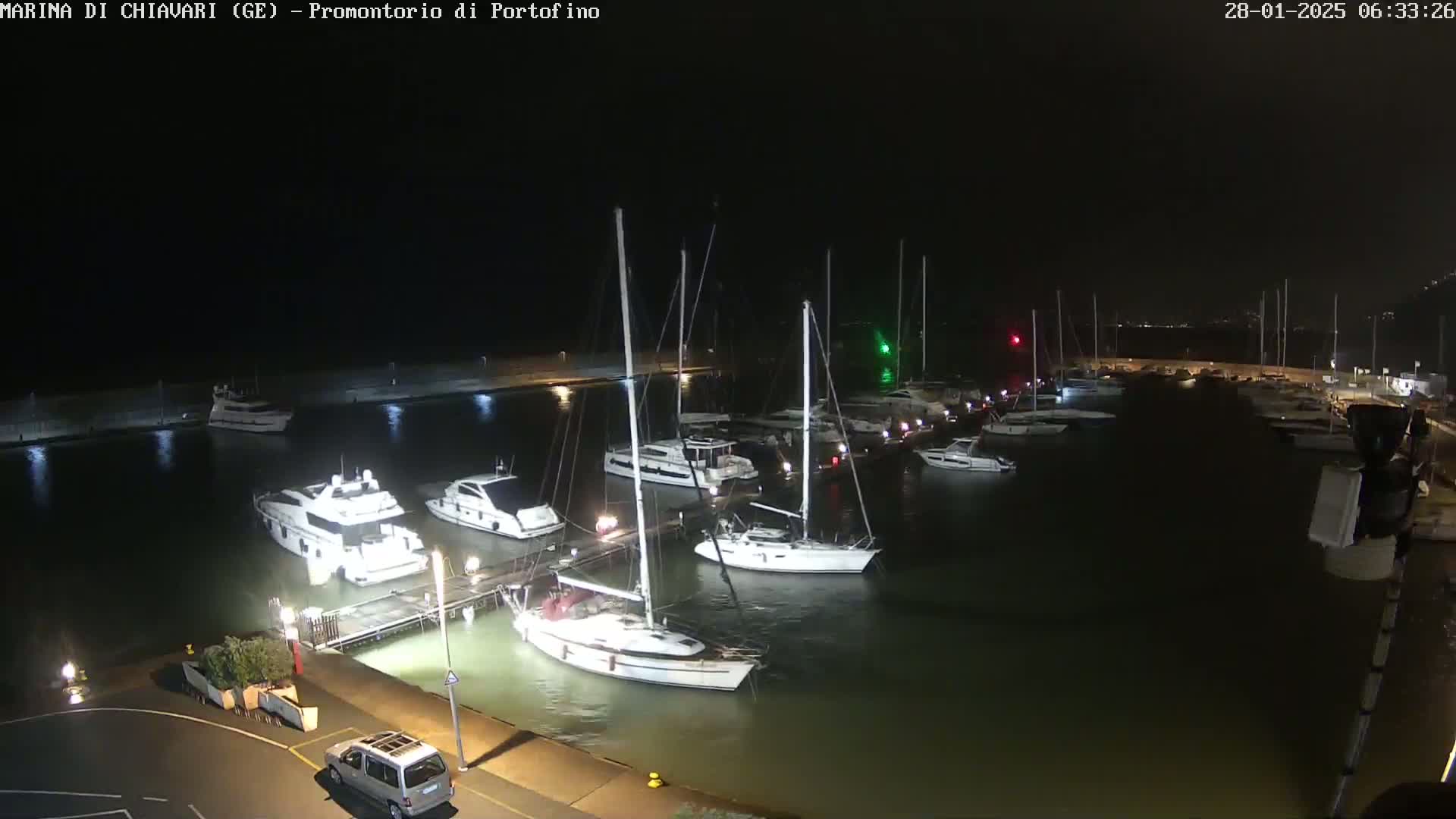 At night, a marina filled with numerous boats and yachts is seen under calm conditions.