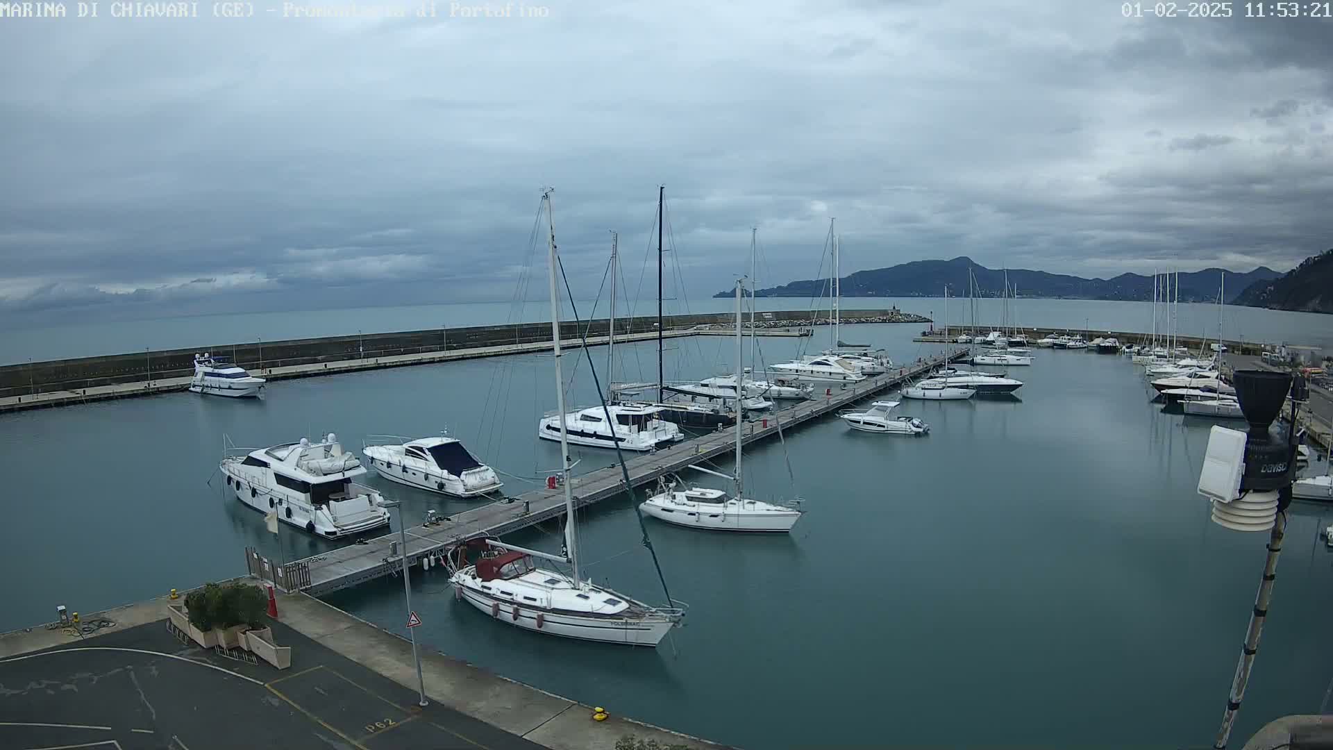 A marina filled with yachts and sailboats on a cloudy day.