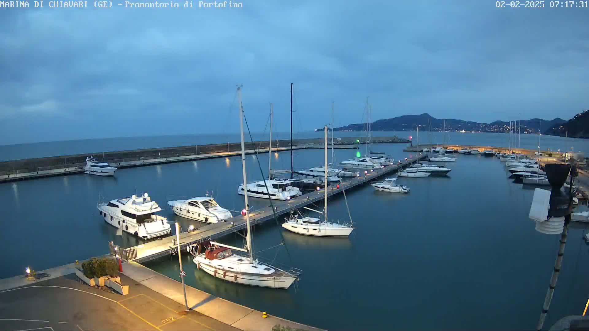 Many boats are moored at a marina under a twilight sky.