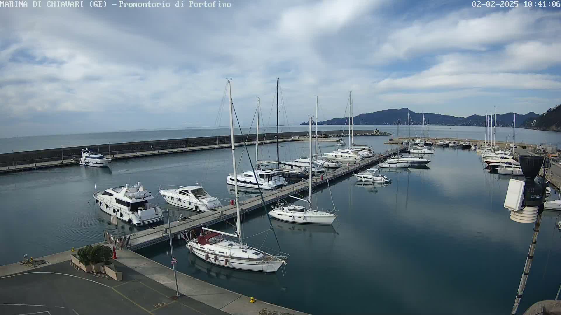 A marina filled with numerous yachts and sailboats under a partly cloudy sky.
