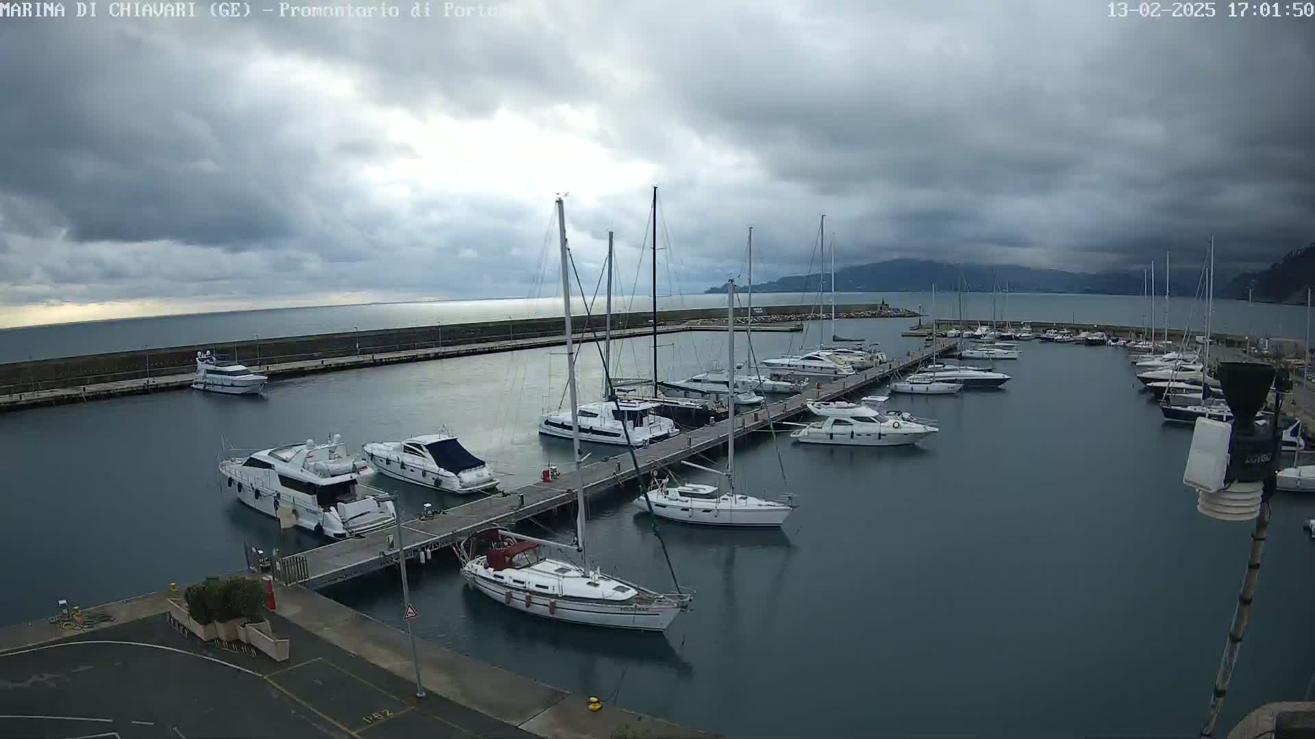 A marina filled with sailboats and motorboats under a cloudy sky.