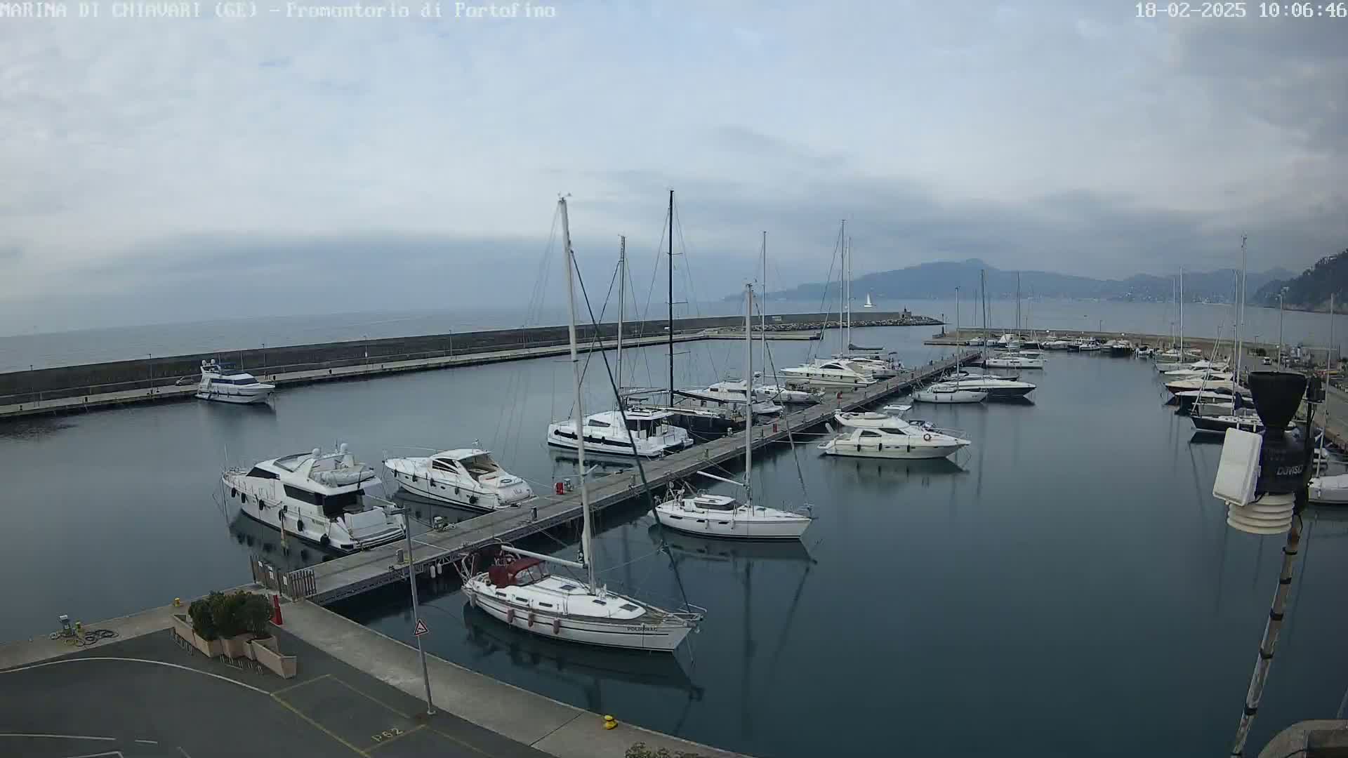 A marina filled with yachts and sailboats on a cloudy day.