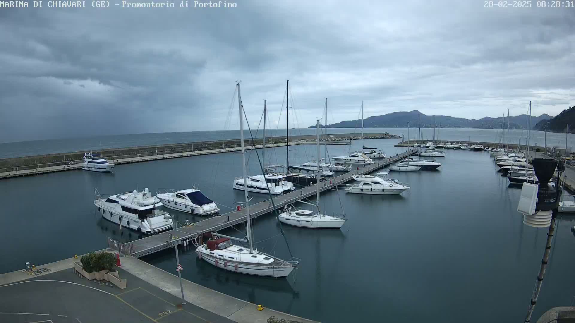 A marina filled with sailboats and motorboats under a cloudy sky.