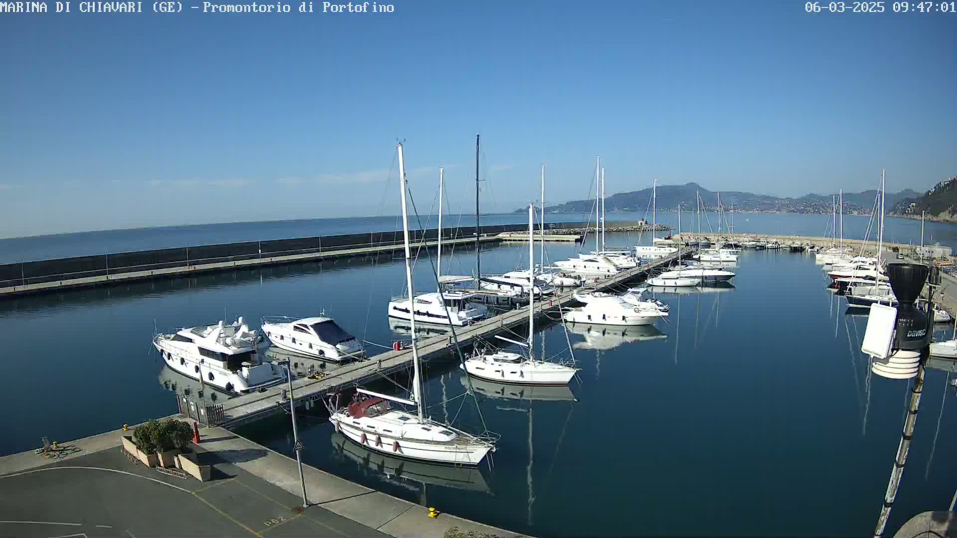 A marina filled with yachts and sailboats on a sunny day.