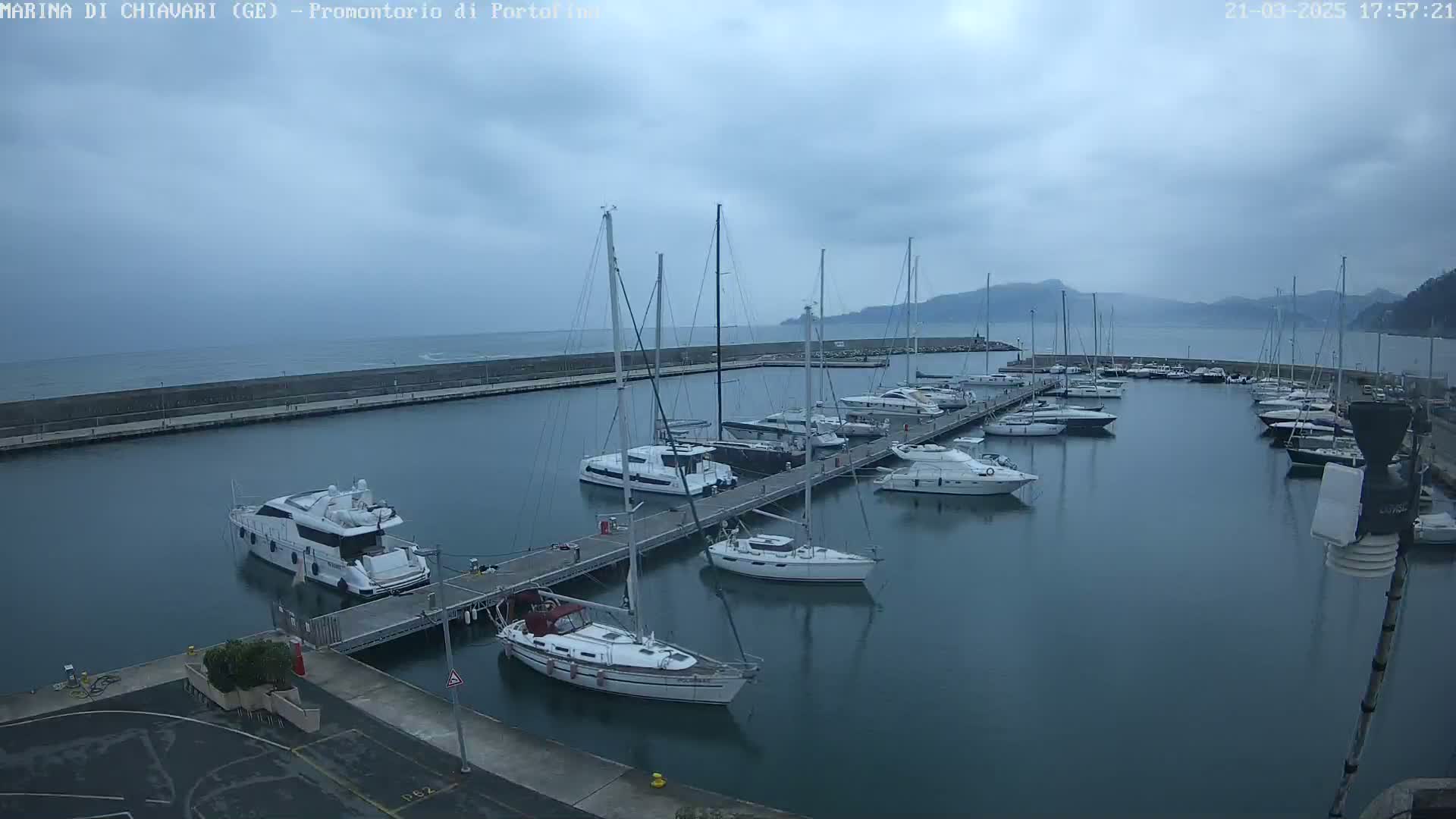 A marina filled with sailboats and motorboats under a cloudy sky.
