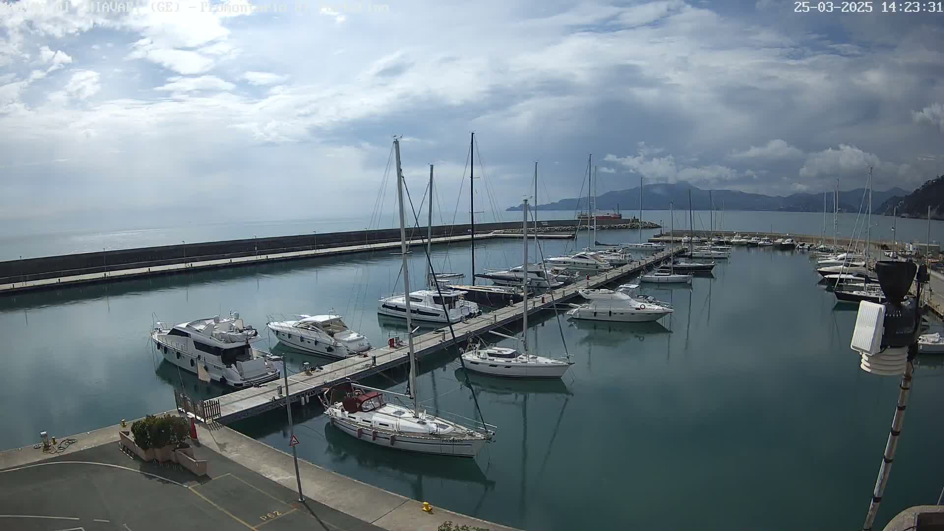 A marina filled with numerous yachts and sailboats under a partly cloudy sky.