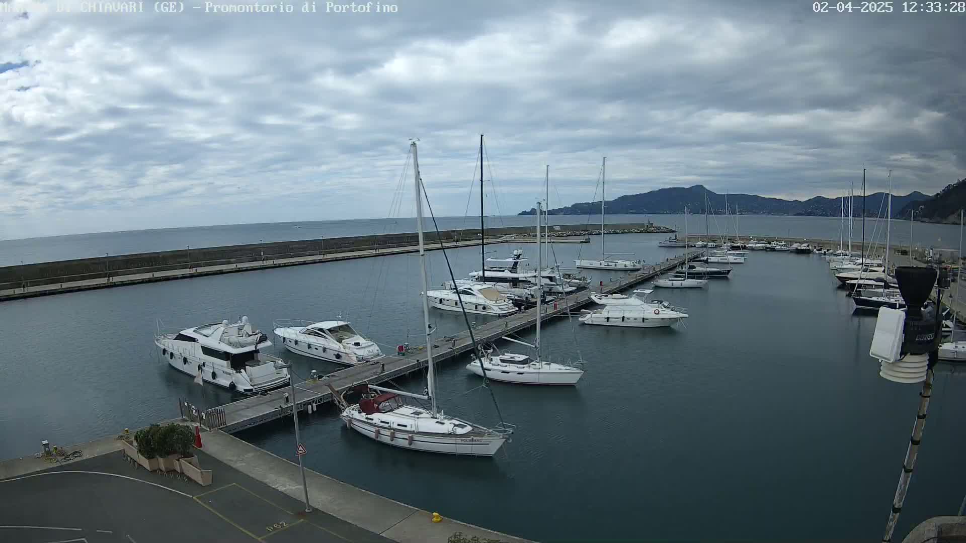 A marina filled with yachts and sailboats under a cloudy sky.