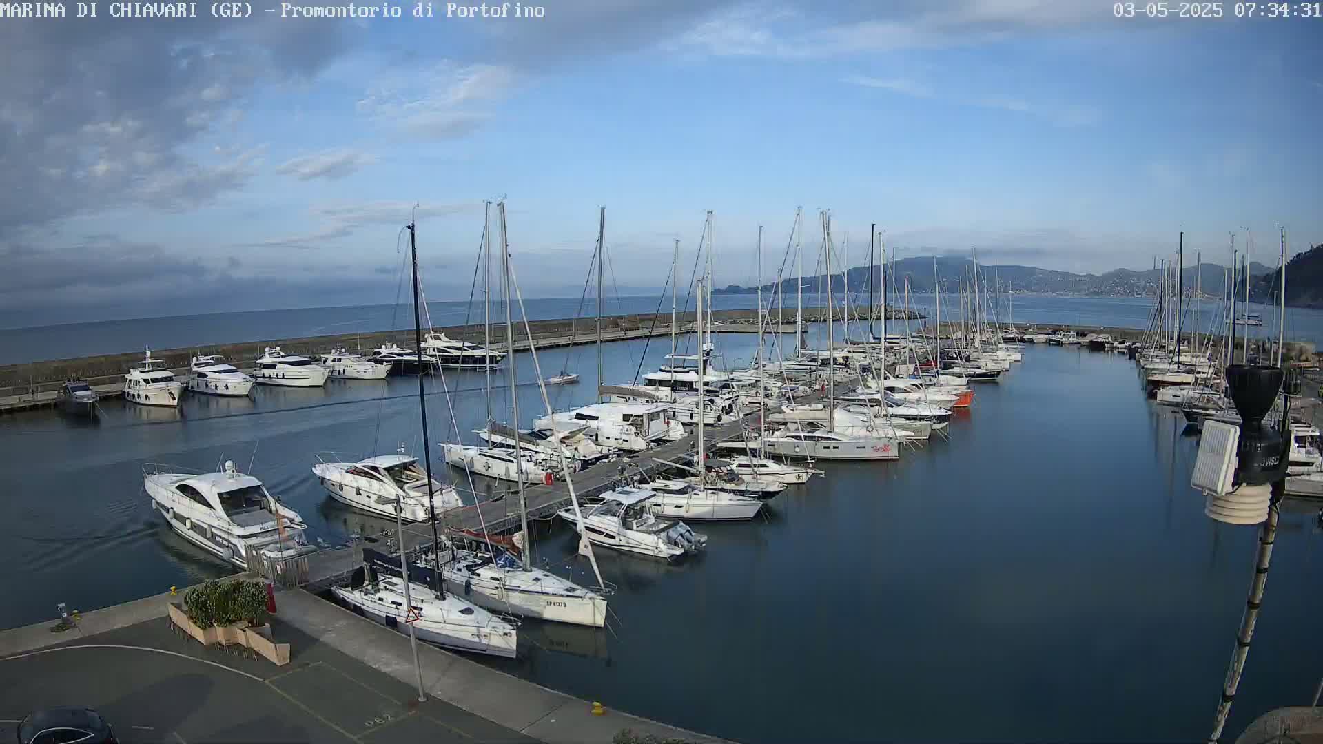 A marina filled with numerous yachts and sailboats under a mostly clear blue sky.