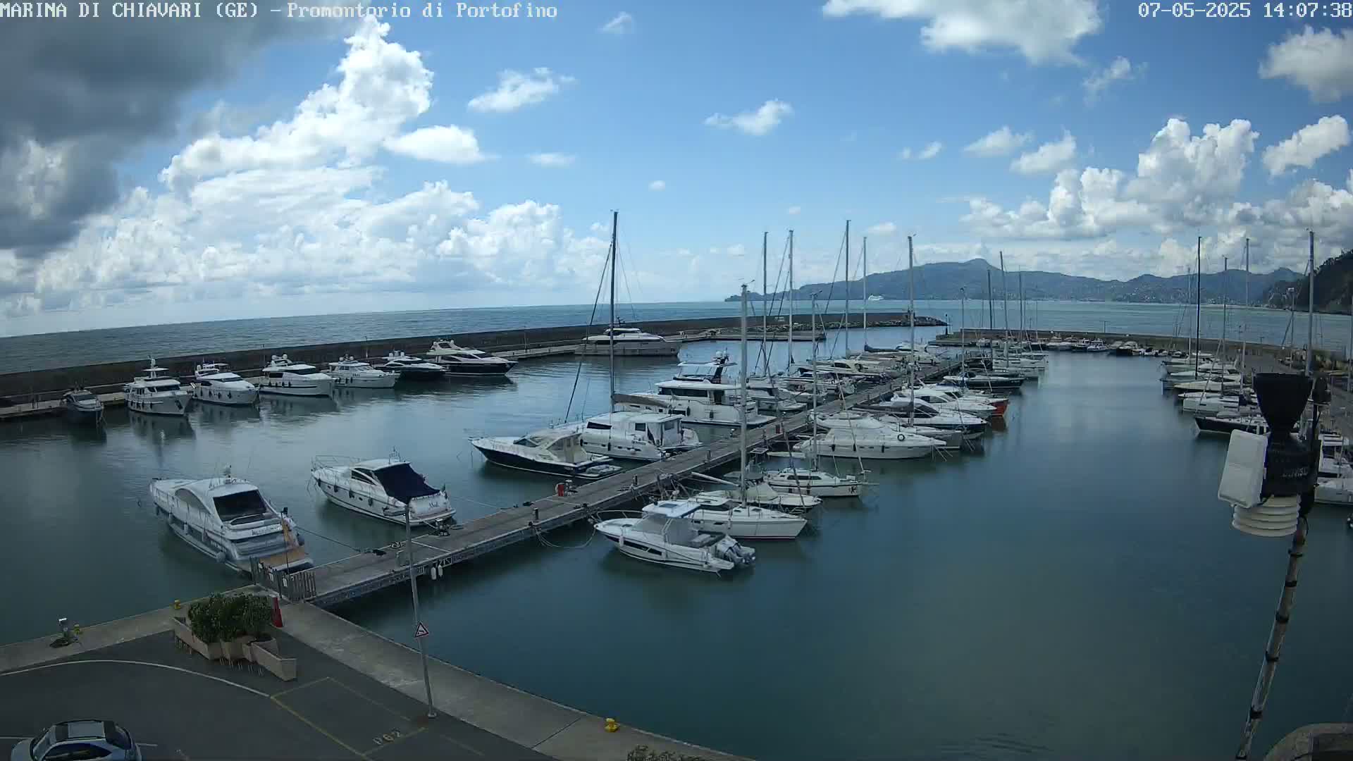 A marina filled with numerous yachts and sailboats under a partly cloudy sky.