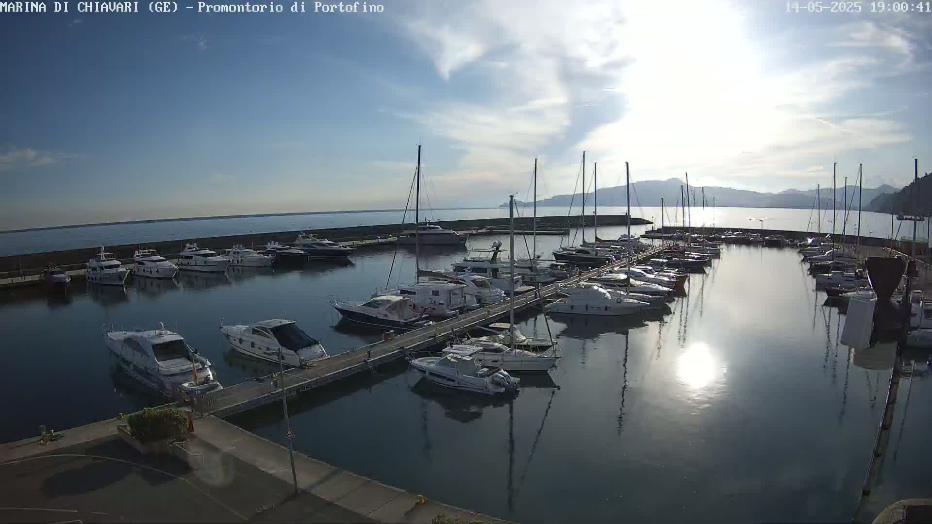 A marina filled with numerous boats and yachts under a partly sunny sky.