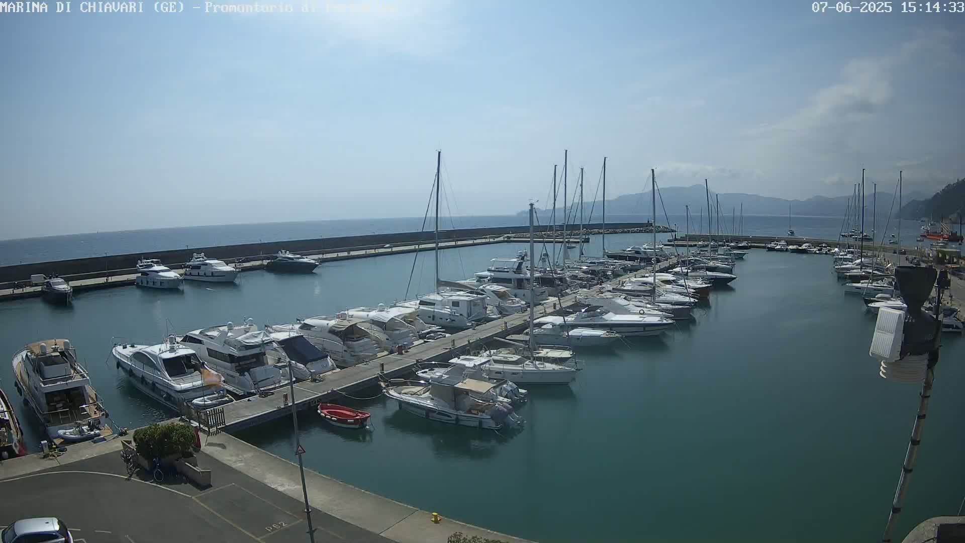 A marina filled with numerous yachts and sailboats under a mostly sunny sky.