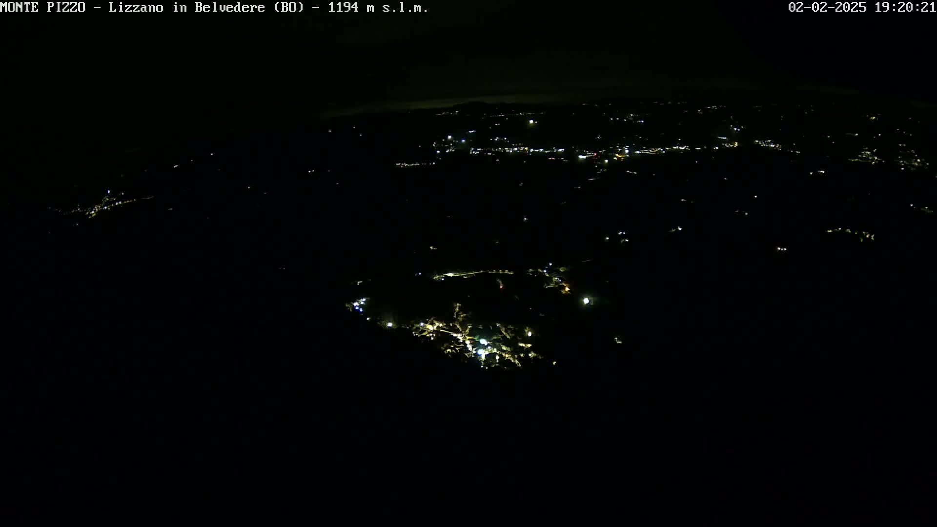 A nighttime aerial view shows a dark landscape sparsely dotted with small, scattered lights.