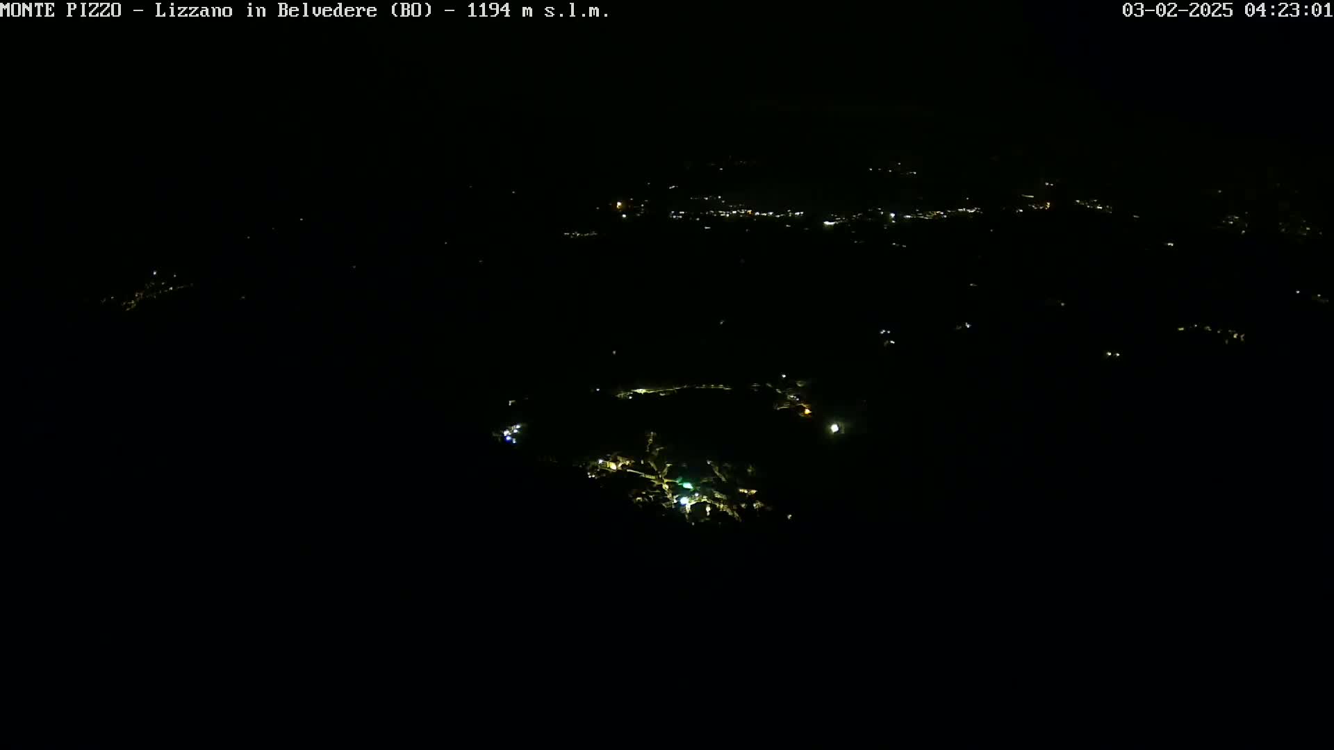 A nighttime, aerial view shows a dark landscape sparsely dotted with small, scattered lights.