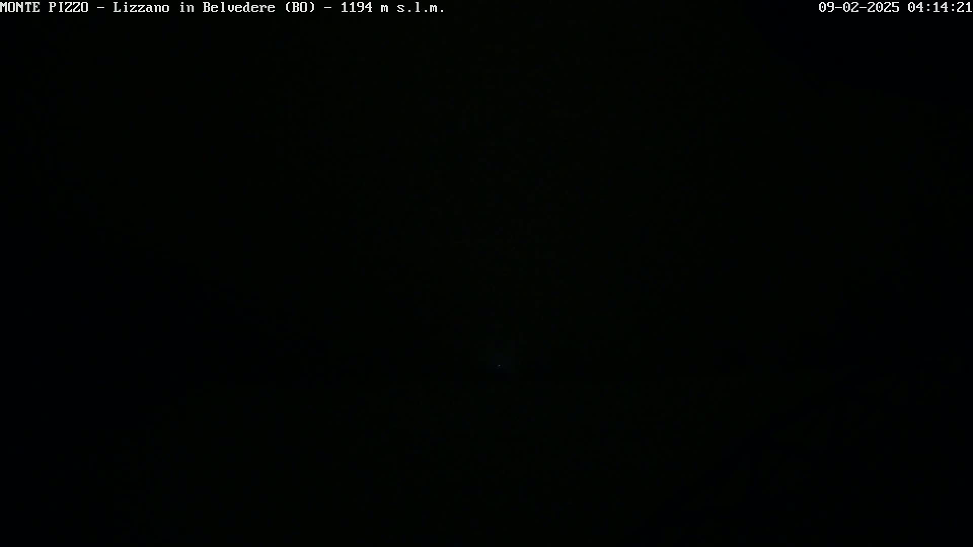The image shows a completely dark nighttime scene with a faint, distant light source.
