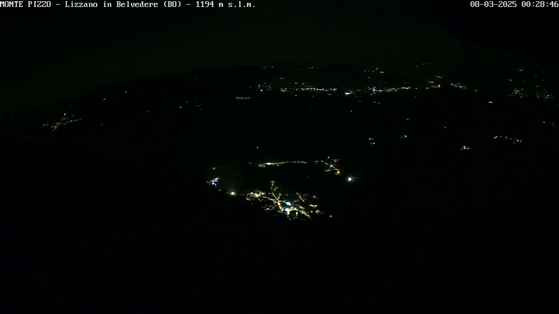 A nighttime, high-angle view shows sparsely scattered lights across a dark landscape.