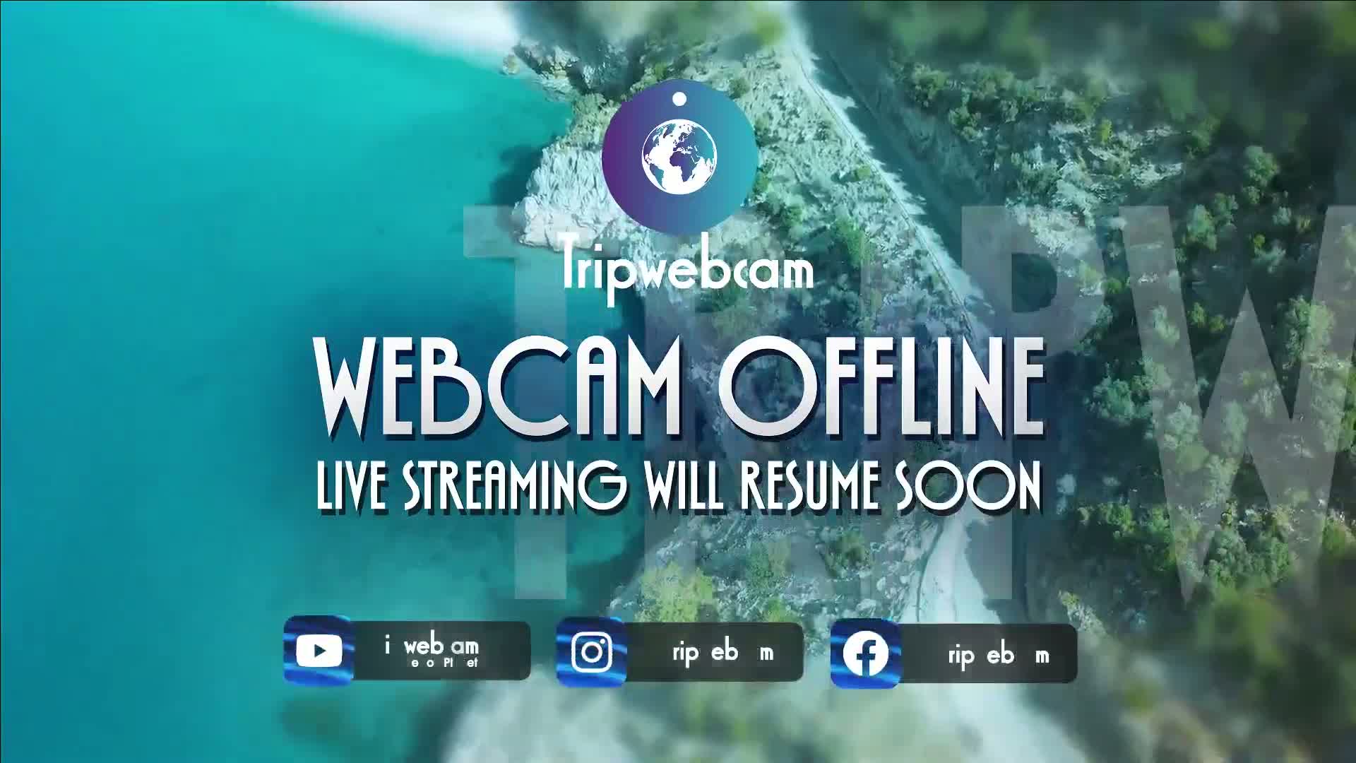 An aerial view of a coastline with turquoise water and green vegetation shows a message that the webcam is offline.