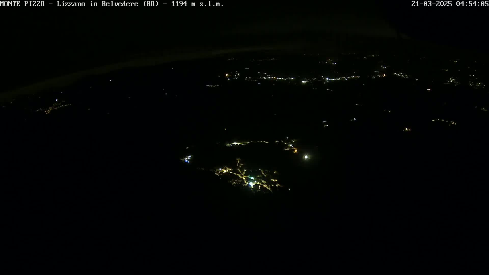 A nighttime aerial view shows a dark landscape sparsely dotted with small, scattered lights.