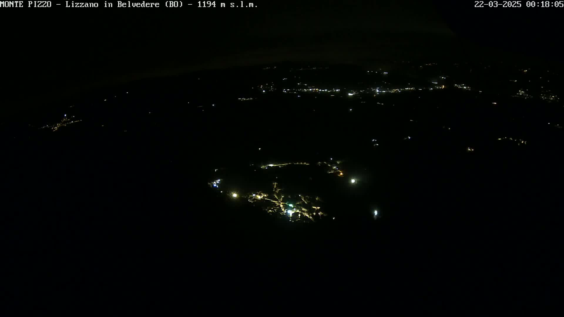 A nighttime aerial view shows a dark landscape with scattered points of light from settlements below.