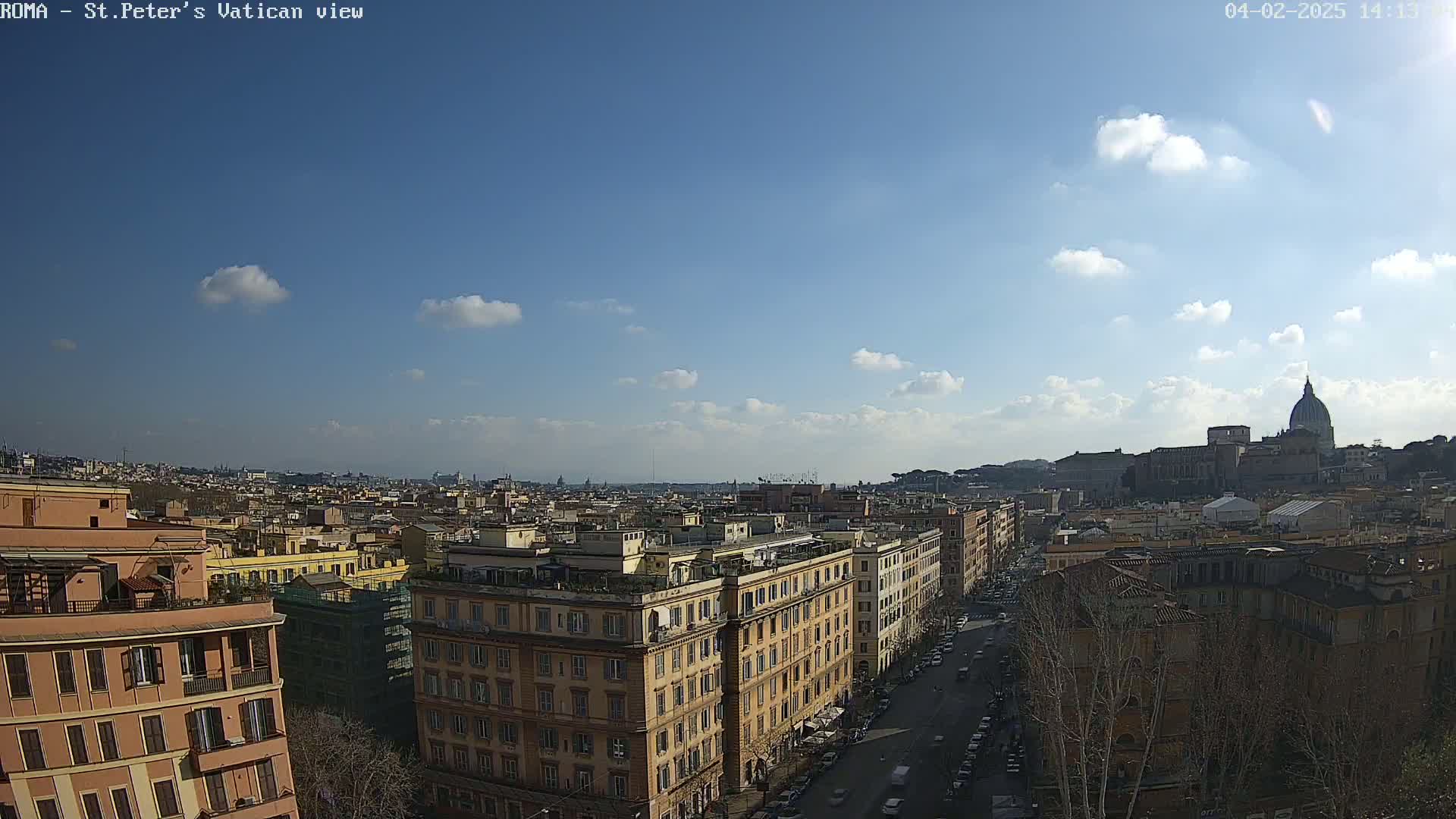 A sunny day reveals a panoramic view of Rome's cityscape, featuring numerous buildings and the dome of St. Peter's Basilica in the distance.