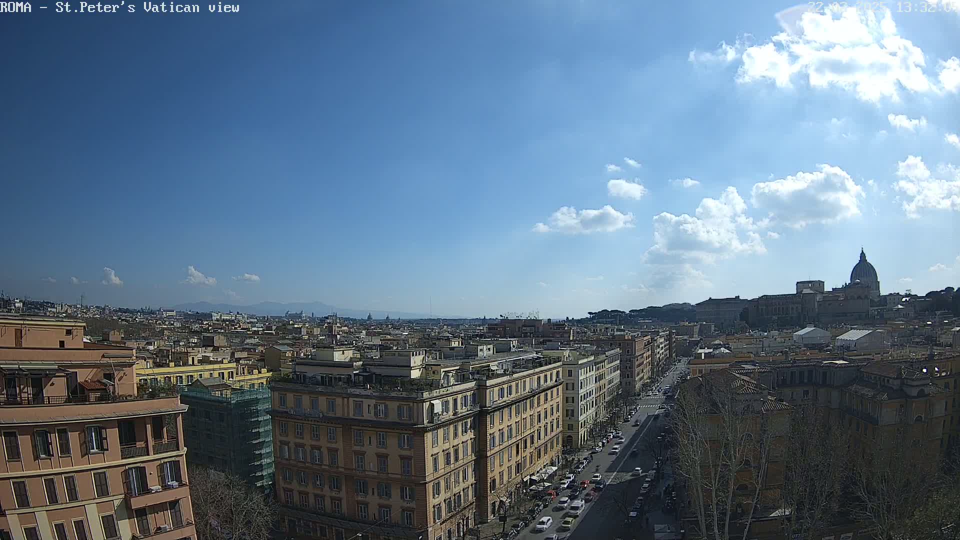 A mostly sunny day reveals a panoramic view of Rome, with the dome of St. Peter's Basilica visible in the distance and a cityscape extending to distant hills.