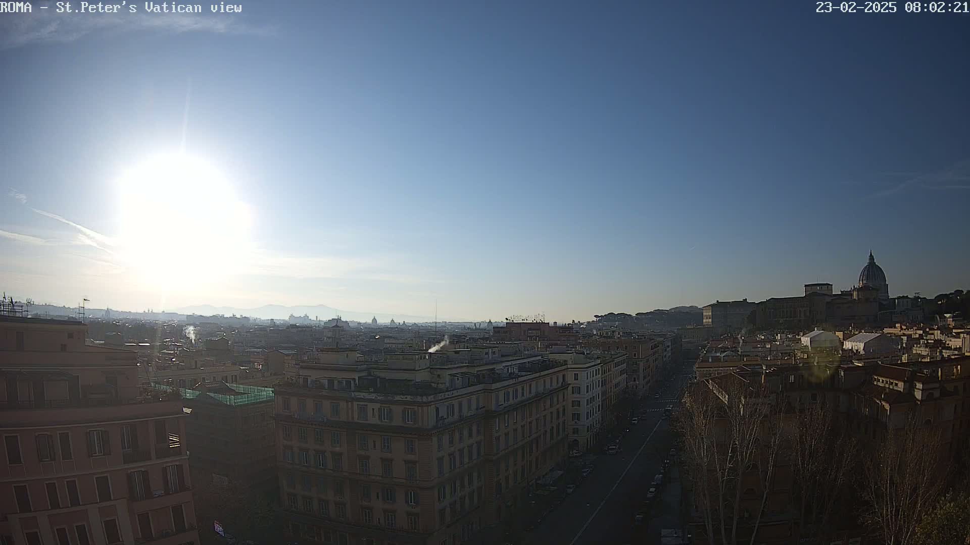 A sunny, clear day reveals a panoramic view of Rome's cityscape, with St. Peter's Basilica visible in the distance.