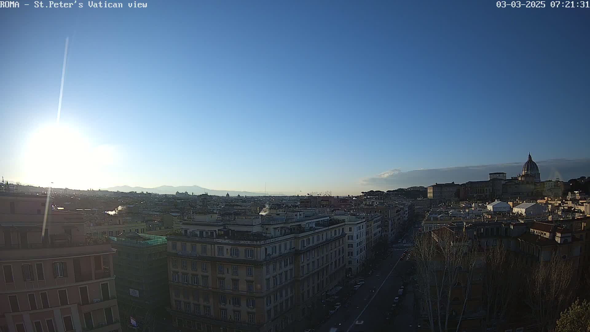 A sunny, clear day reveals a panoramic view of Rome's cityscape, featuring St. Peter's Basilica in the distance.