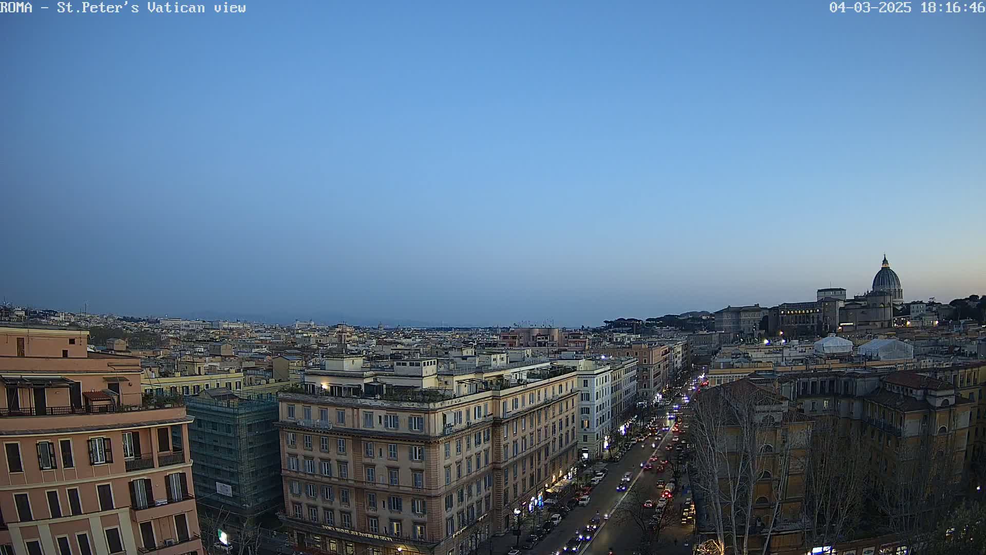 A twilight view of Rome, showing a cityscape with the dome of St. Peter's Basilica in the distance under a clear sky.