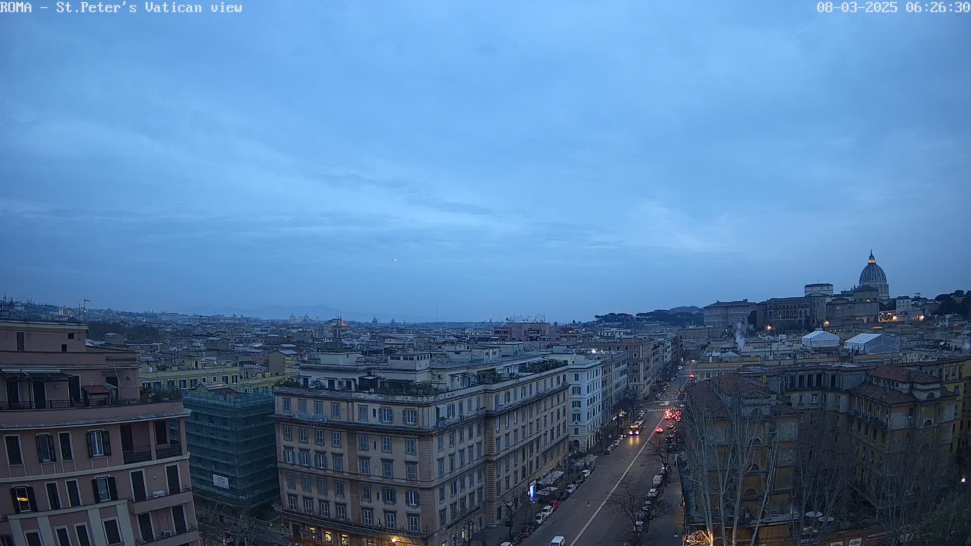 A twilight view of Rome shows a cityscape extending to St. Peter's Basilica under a mostly clear, dusky sky.