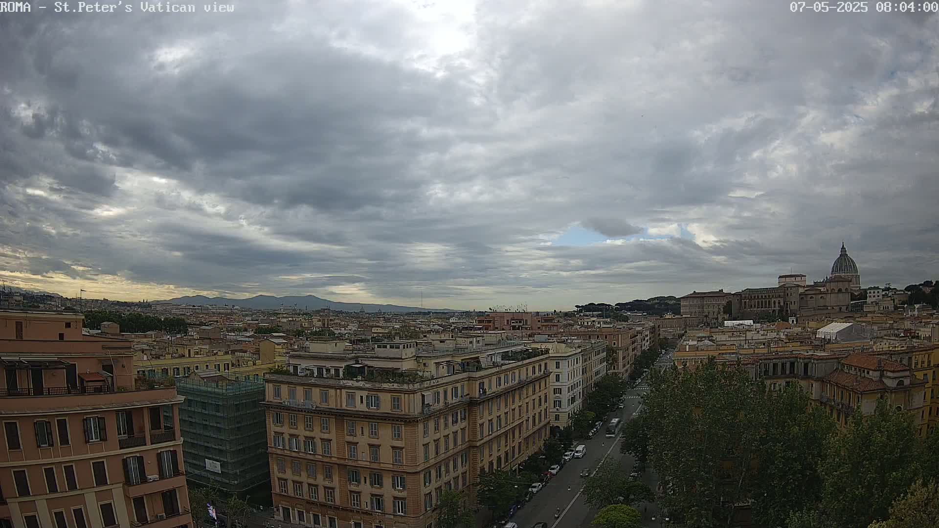 A cloudy sky hangs over a cityscape of Roman buildings, with St. Peter's Basilica visible in the distance.