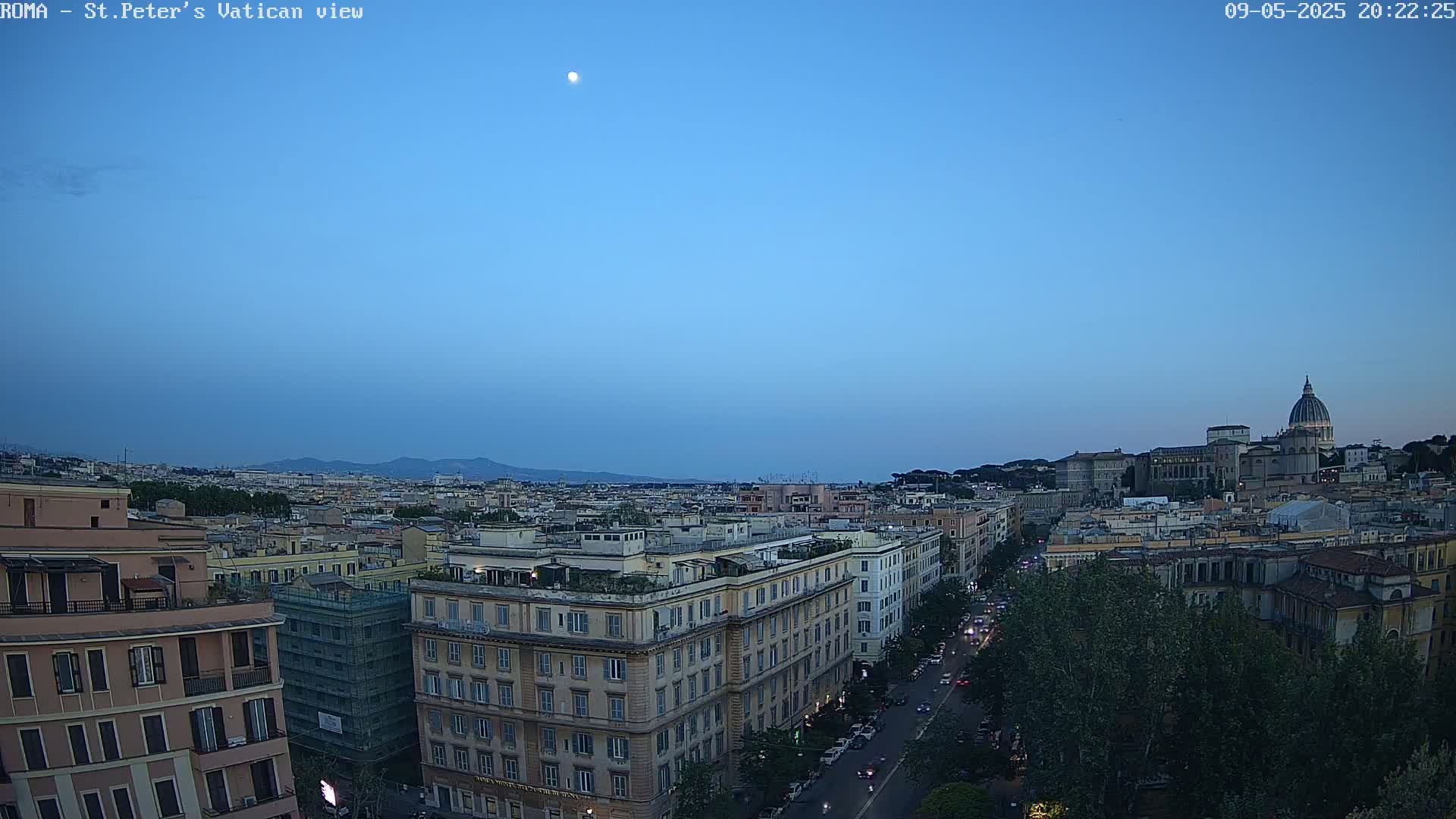 A twilight view of Rome's cityscape, featuring the dome of St. Peter's Basilica in the distance, under a clear, moonlit sky.