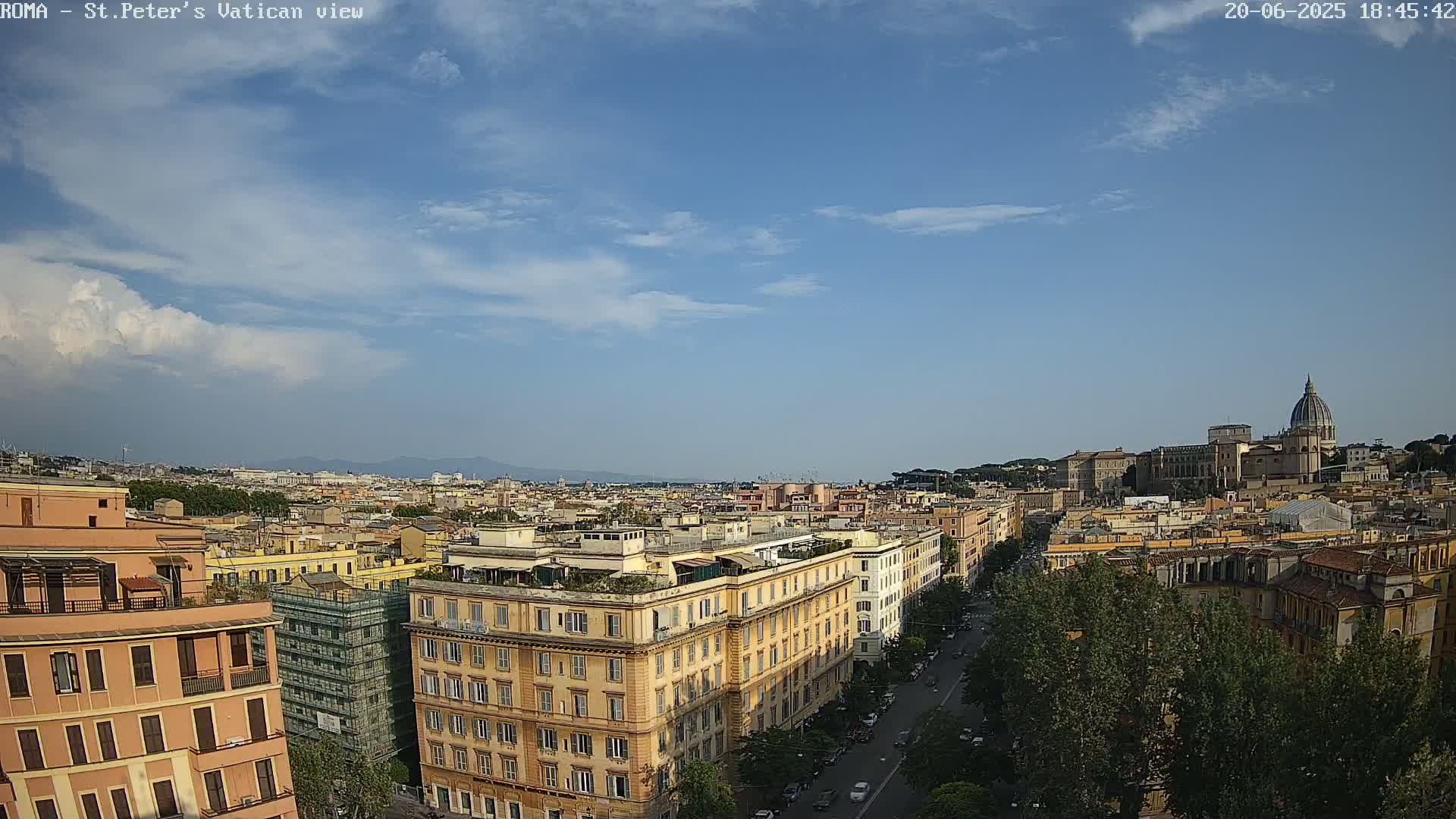 A partly cloudy sky overlooks a cityscape of Roman buildings, including a large church dome in the distance.