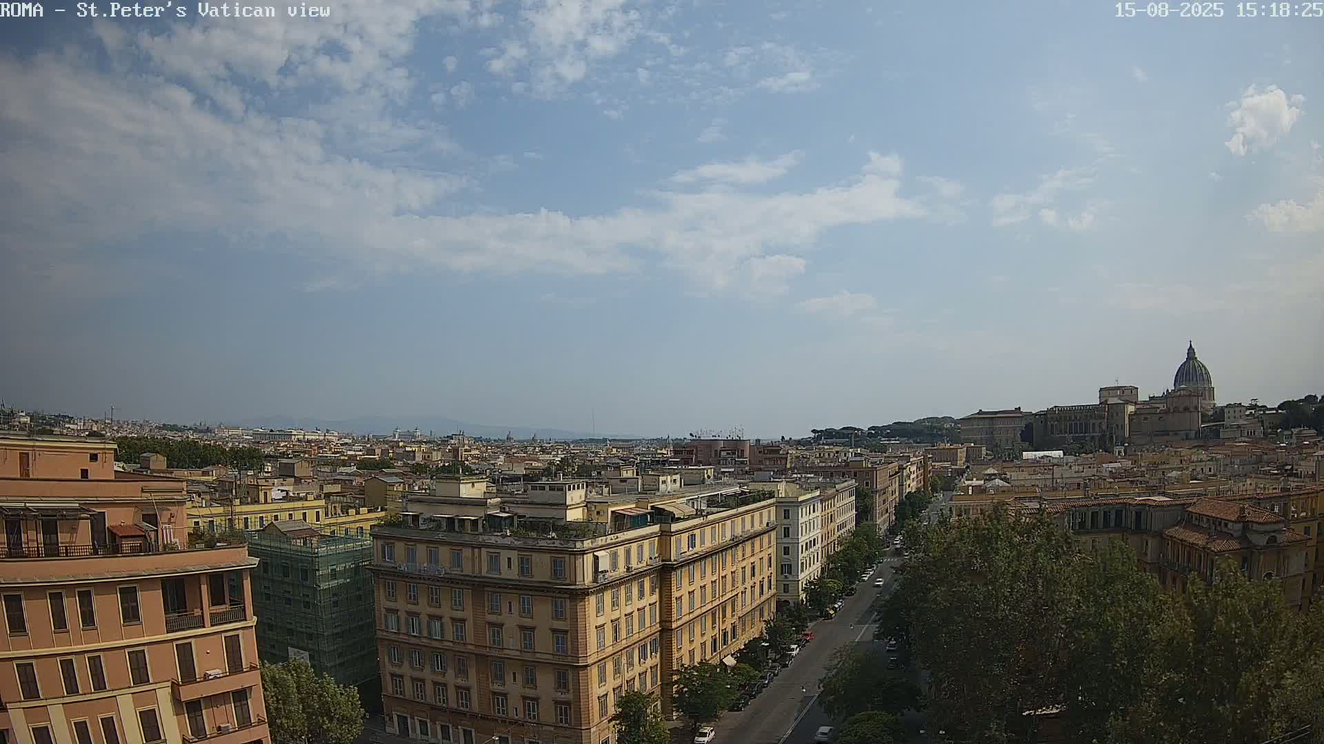 A mostly cloudy sky overlooks a cityscape with a large dome-shaped building in the distance.