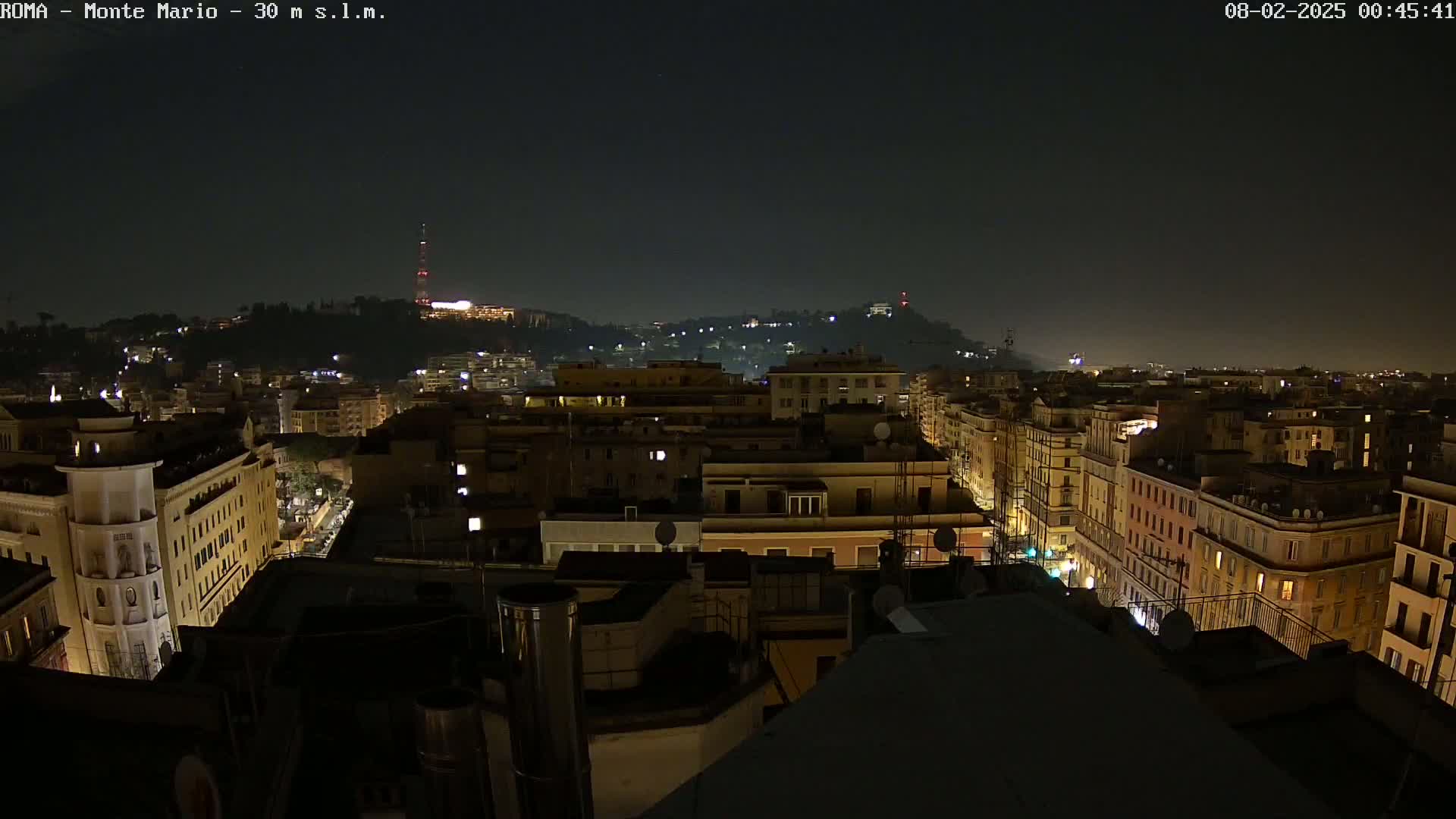 A nighttime cityscape of buildings illuminated by lights under a clear, dark sky.