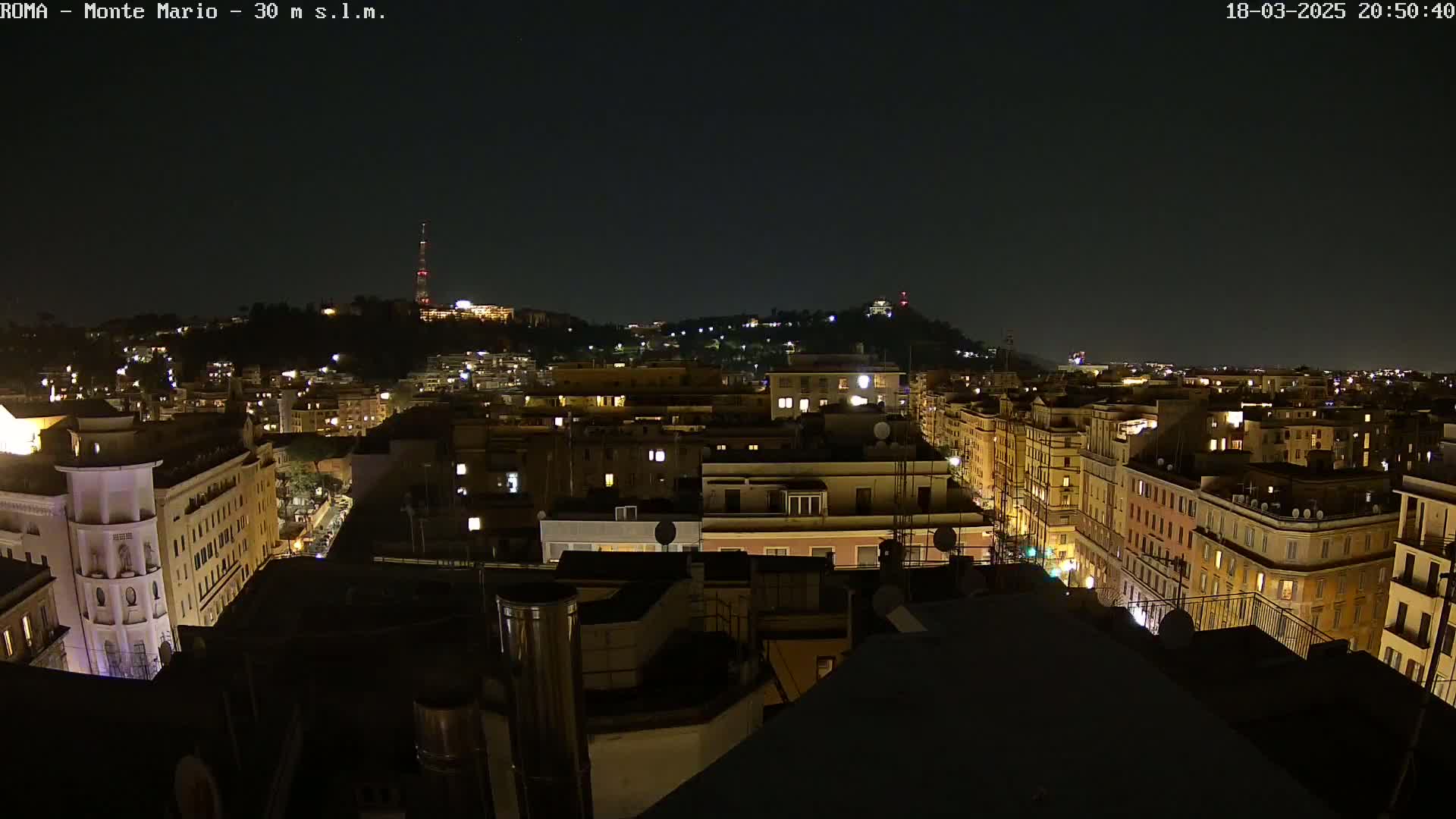 A nighttime aerial view of a city with many illuminated buildings, under a clear, dark sky.
