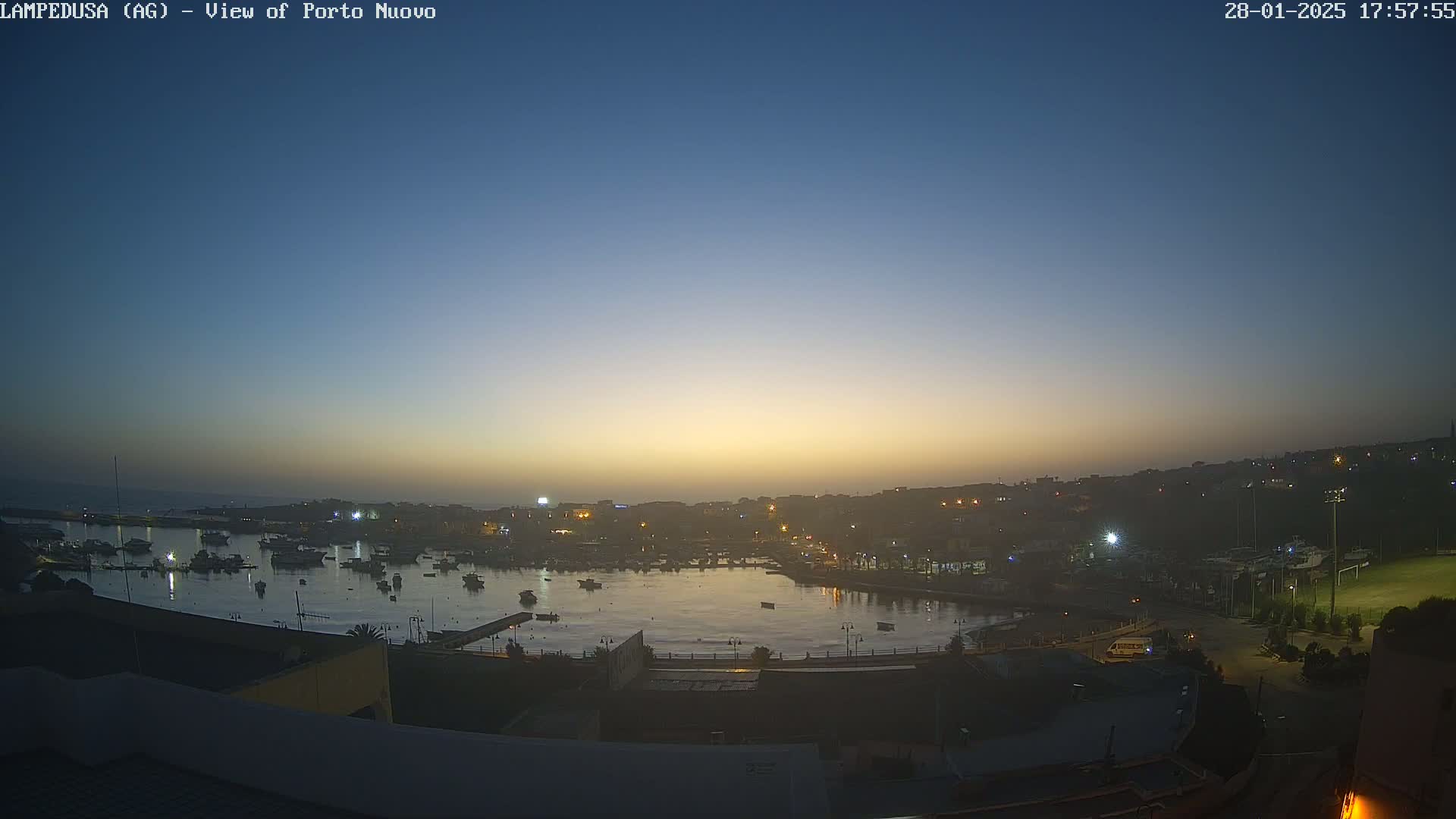 A harbor filled with boats at dusk under a clear, twilight sky.