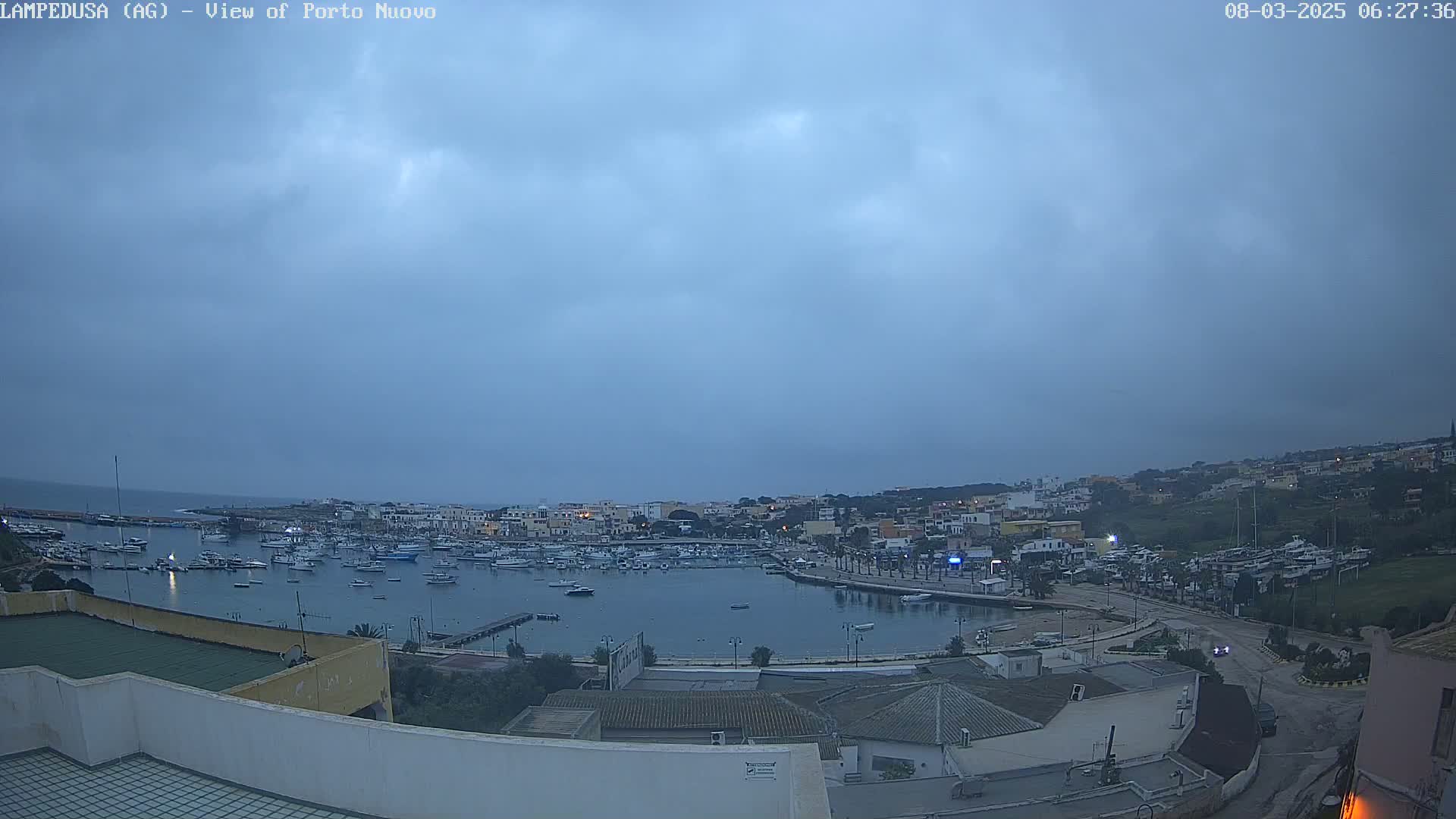 A harbor filled with boats is seen under an overcast sky.