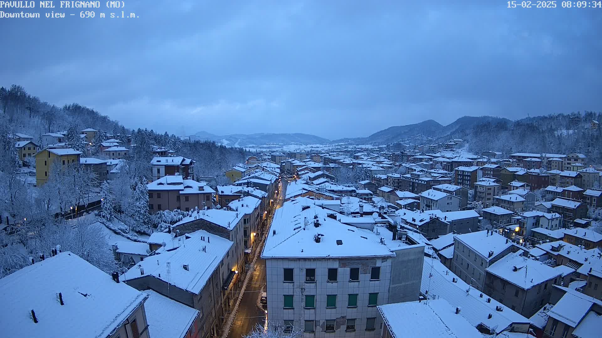 A snow-covered town nestled in a valley under a twilight sky.