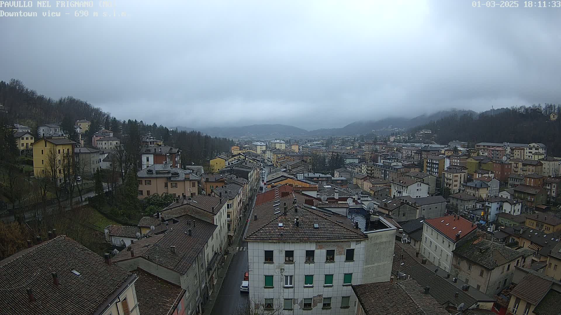 A sprawling town nestled in a valley under a cloudy, overcast sky.