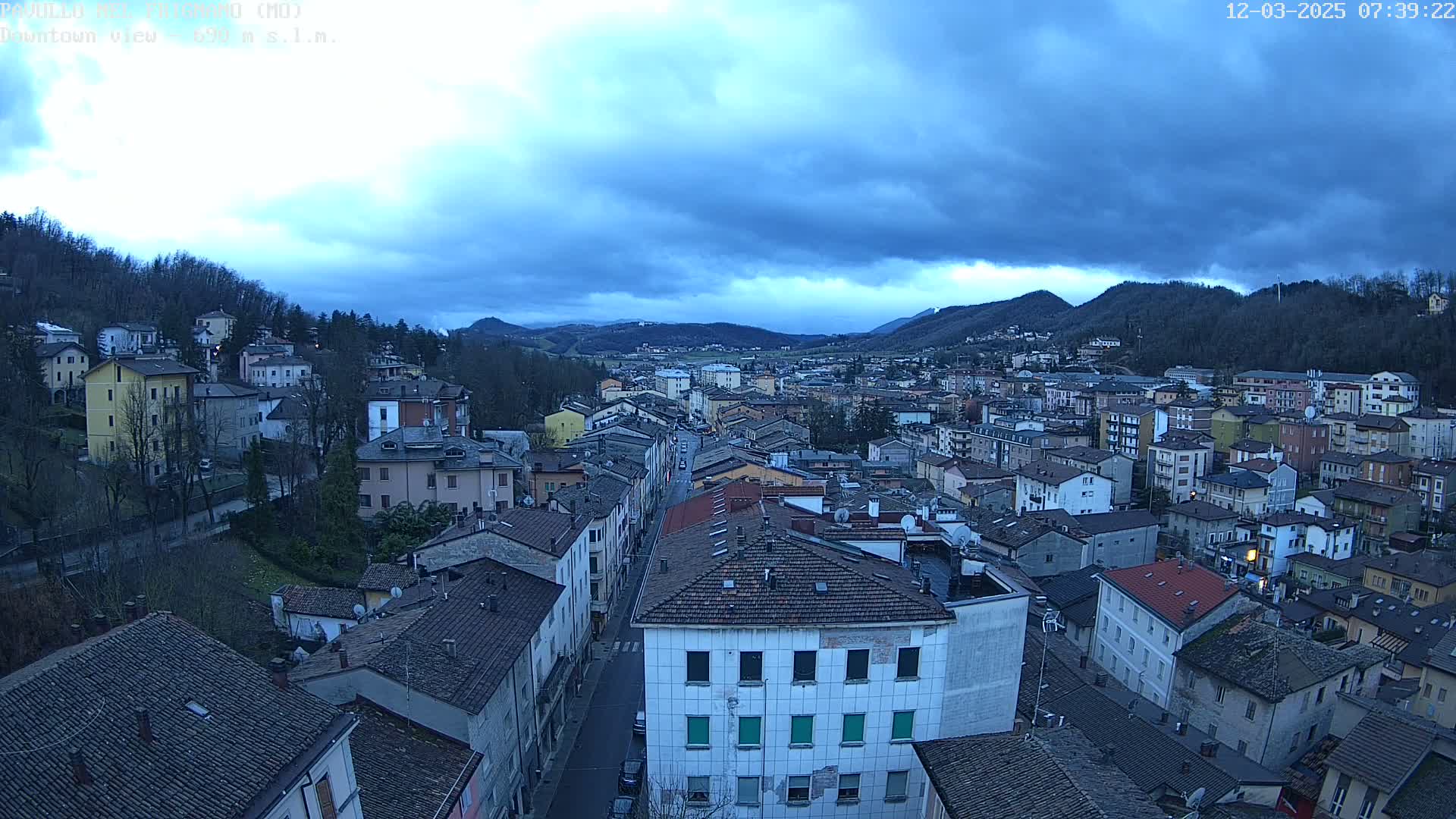 A sprawling town nestled in a valley under a cloudy, overcast sky.