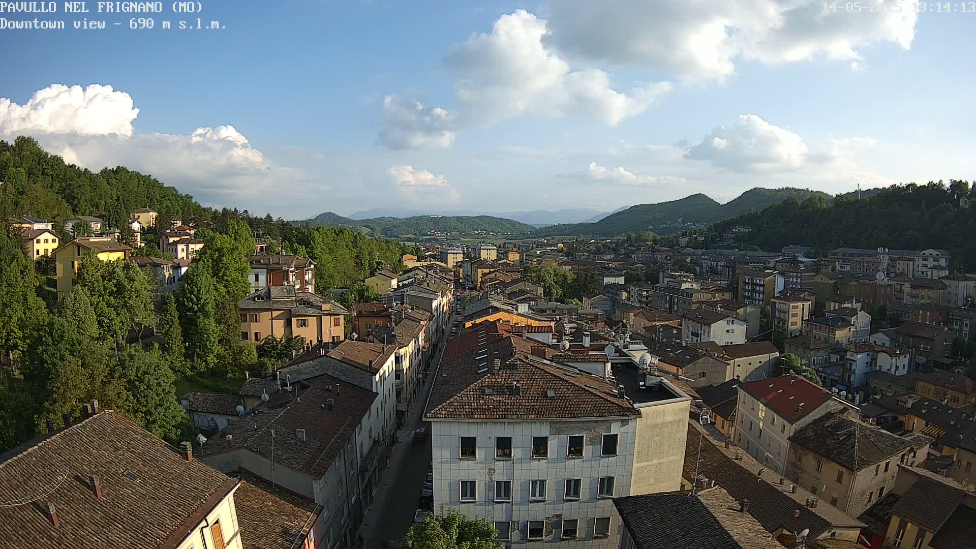 An elevated view of a town nestled in a valley under a partly cloudy sky.