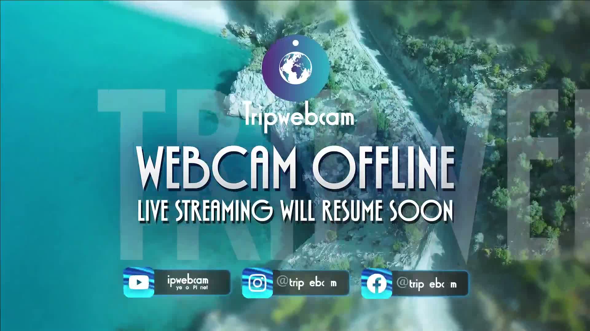 An aerial view of a rocky coastline with teal water shows a live webcam temporarily offline.