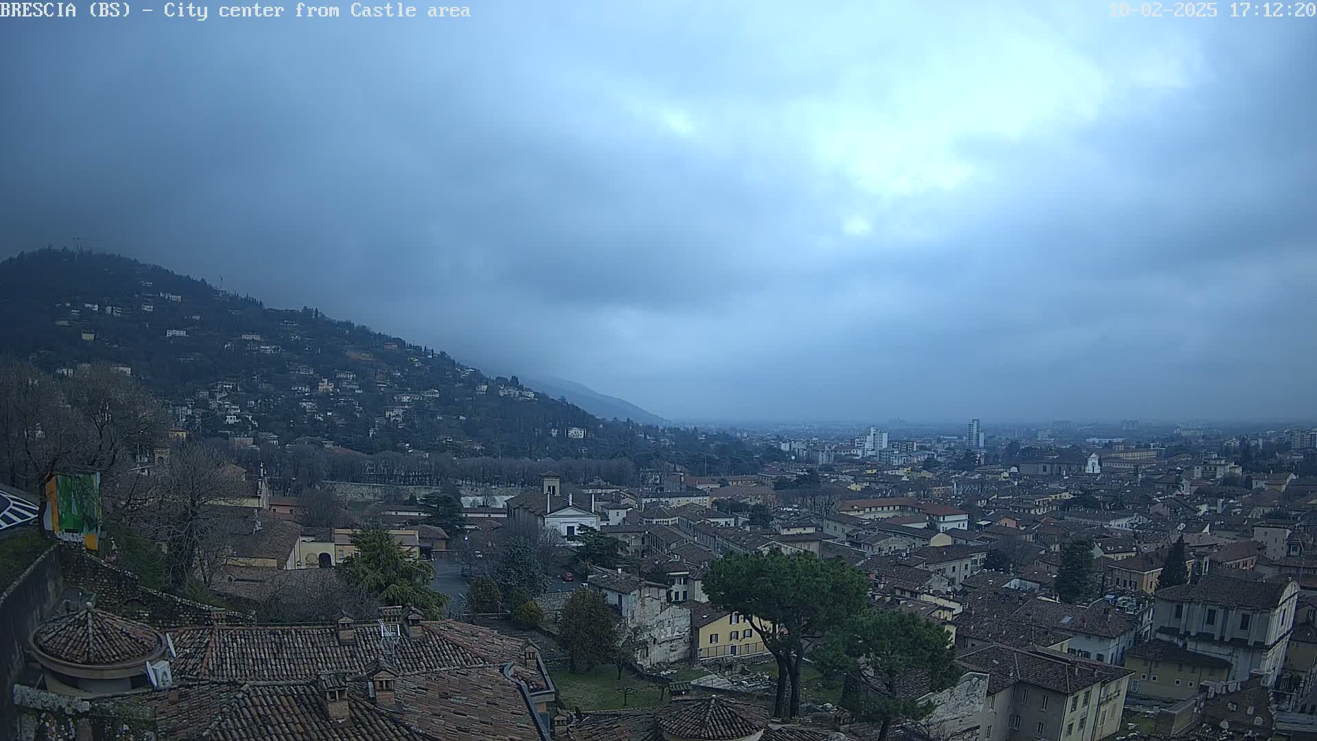 A sprawling city with numerous buildings under a cloudy sky.