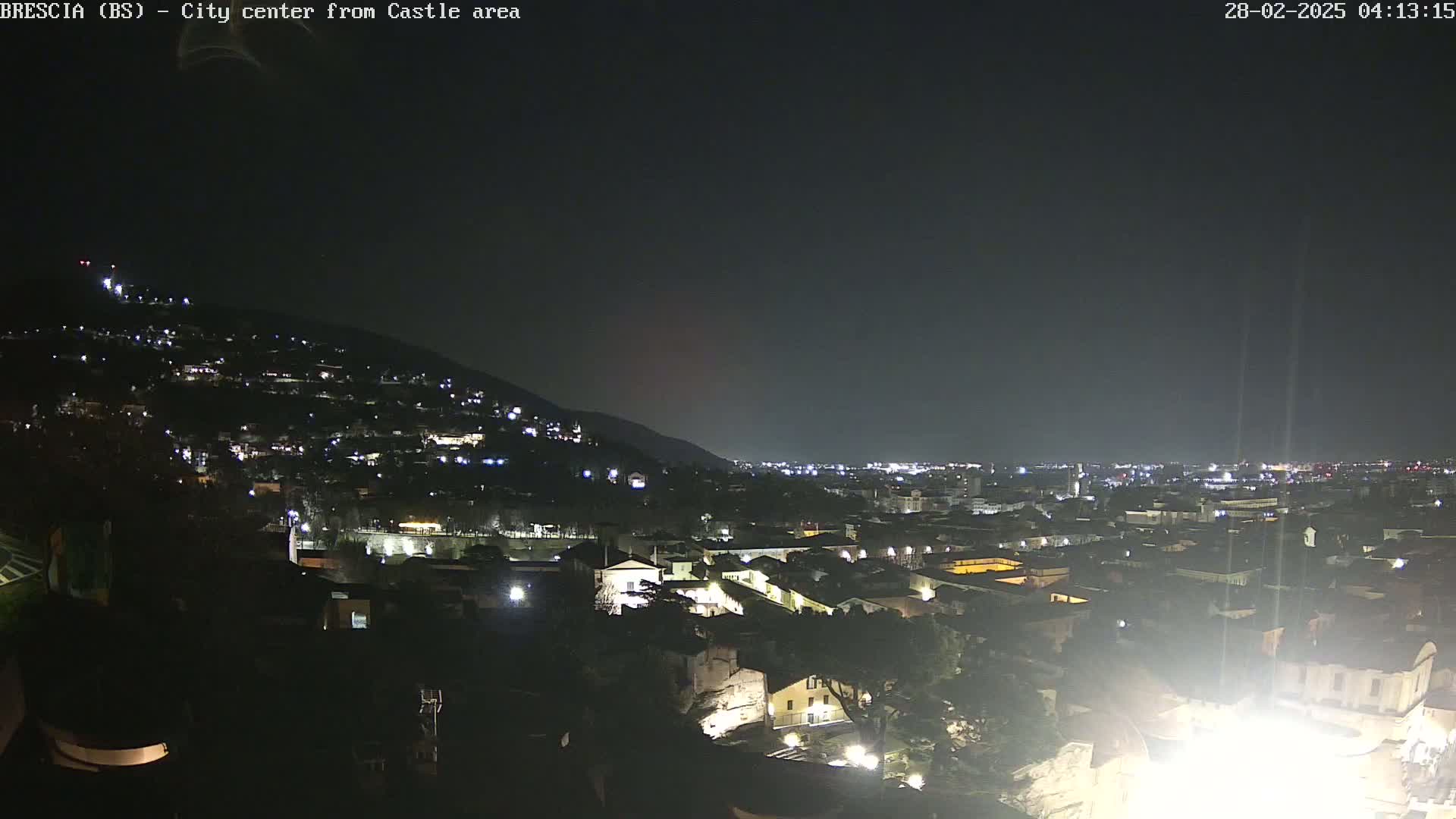 A nighttime view of a city sprawling across a hillside under a clear, dark sky.
