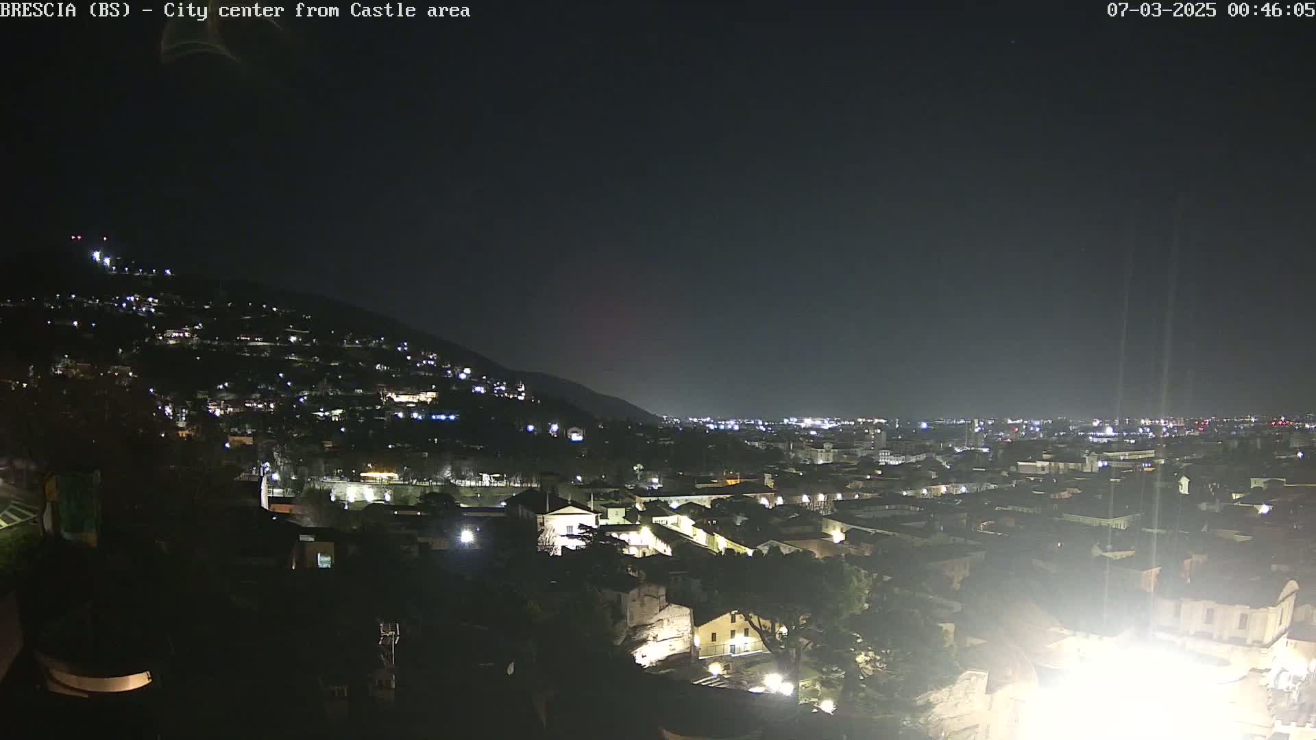 A nighttime view of a city sprawling across a hillside under a clear, dark sky.