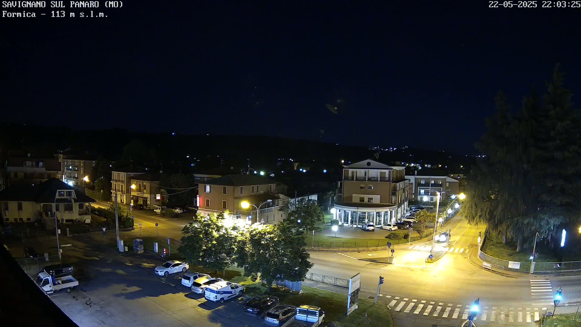 A nighttime, aerial view of a town's streets and buildings illuminated by streetlights under a clear, dark sky.