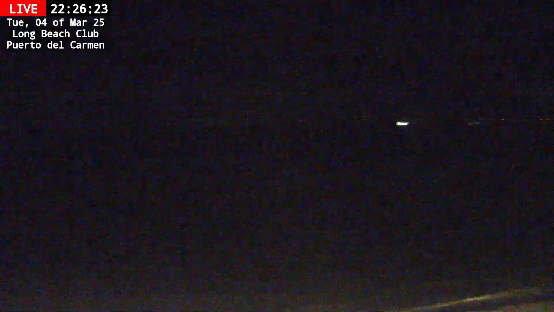 A nighttime, dark view of a distant, faintly lit horizon.