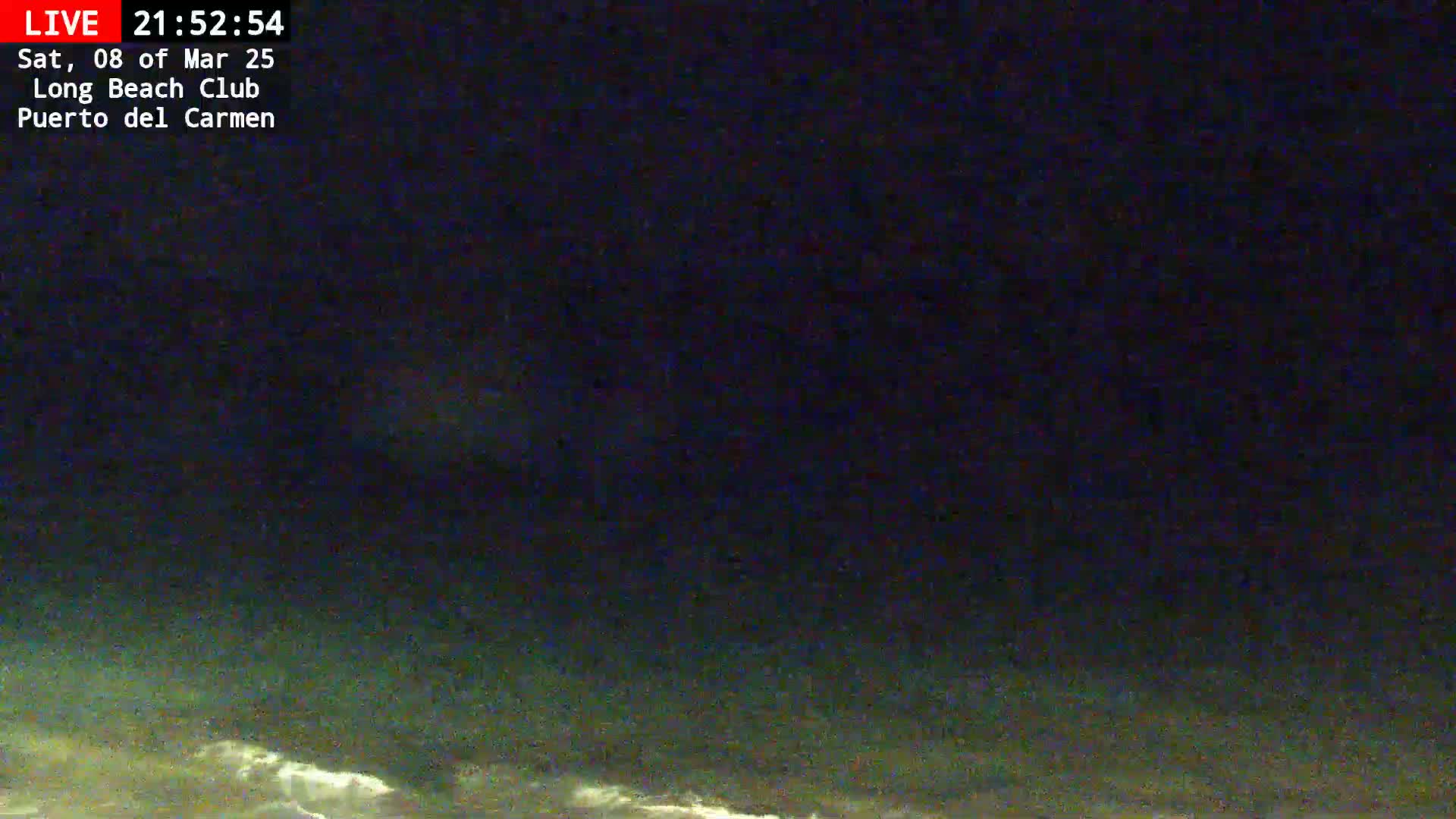 A nighttime view shows dark water with slight wave action under a dark sky.