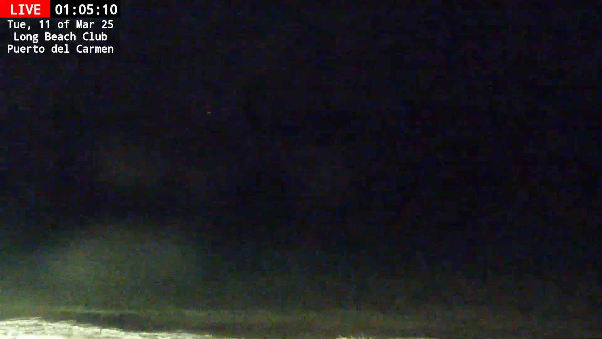 A dark, nighttime scene shows a body of water with waves at the bottom of the frame under a mostly clear, dark sky.