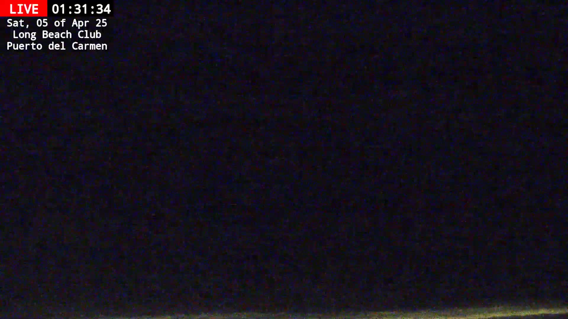 A nighttime, dark image shows a mostly black scene with a faint, light horizon line at the bottom.